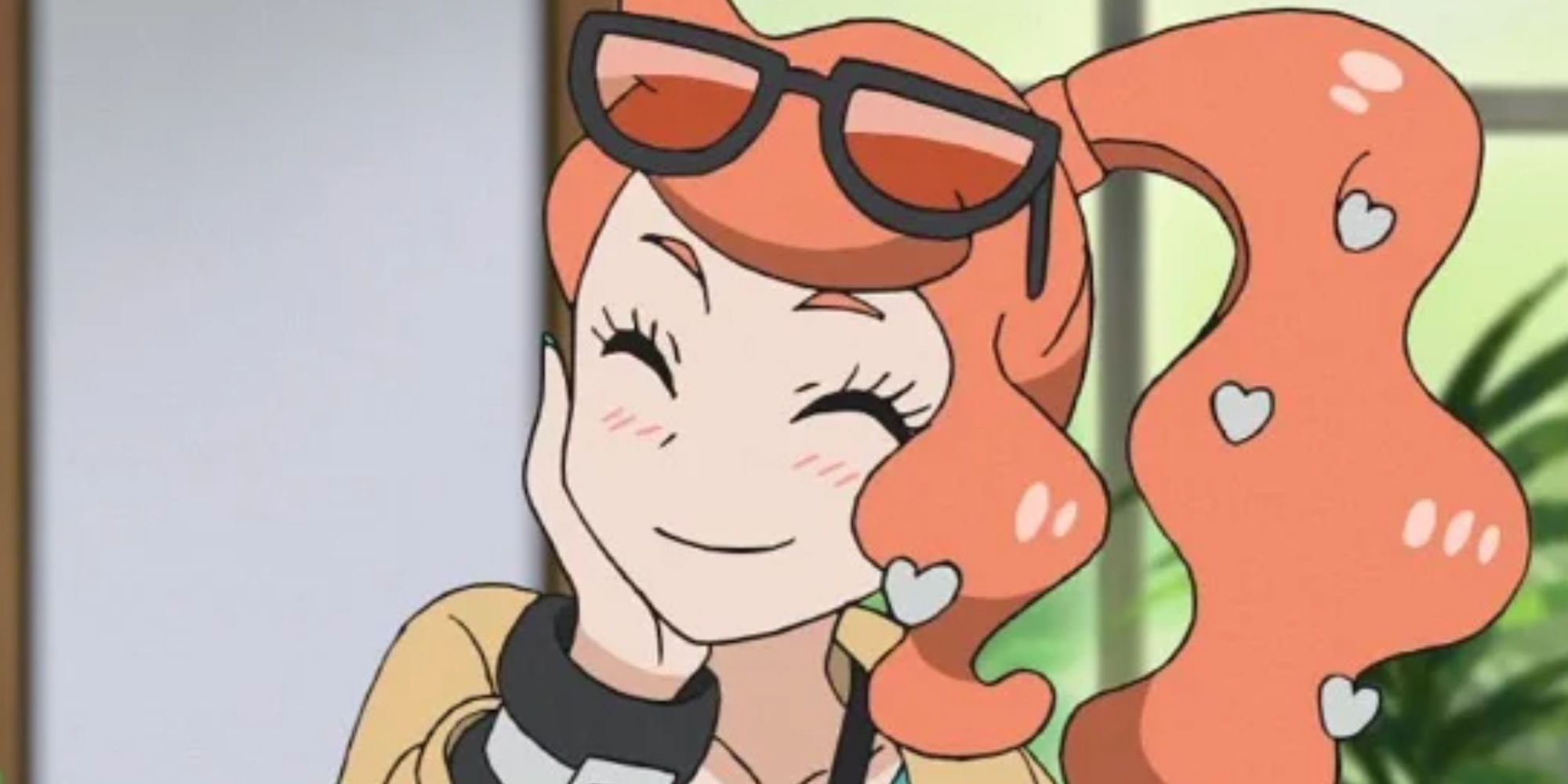Sonia from the Pokemon anime. A young woman with red hair adorned with silver hearts, tied back into a ponytail. Sunglasses sit on top of her head. She's smiling, eyes closed, while she holds one hand against the side of her face.