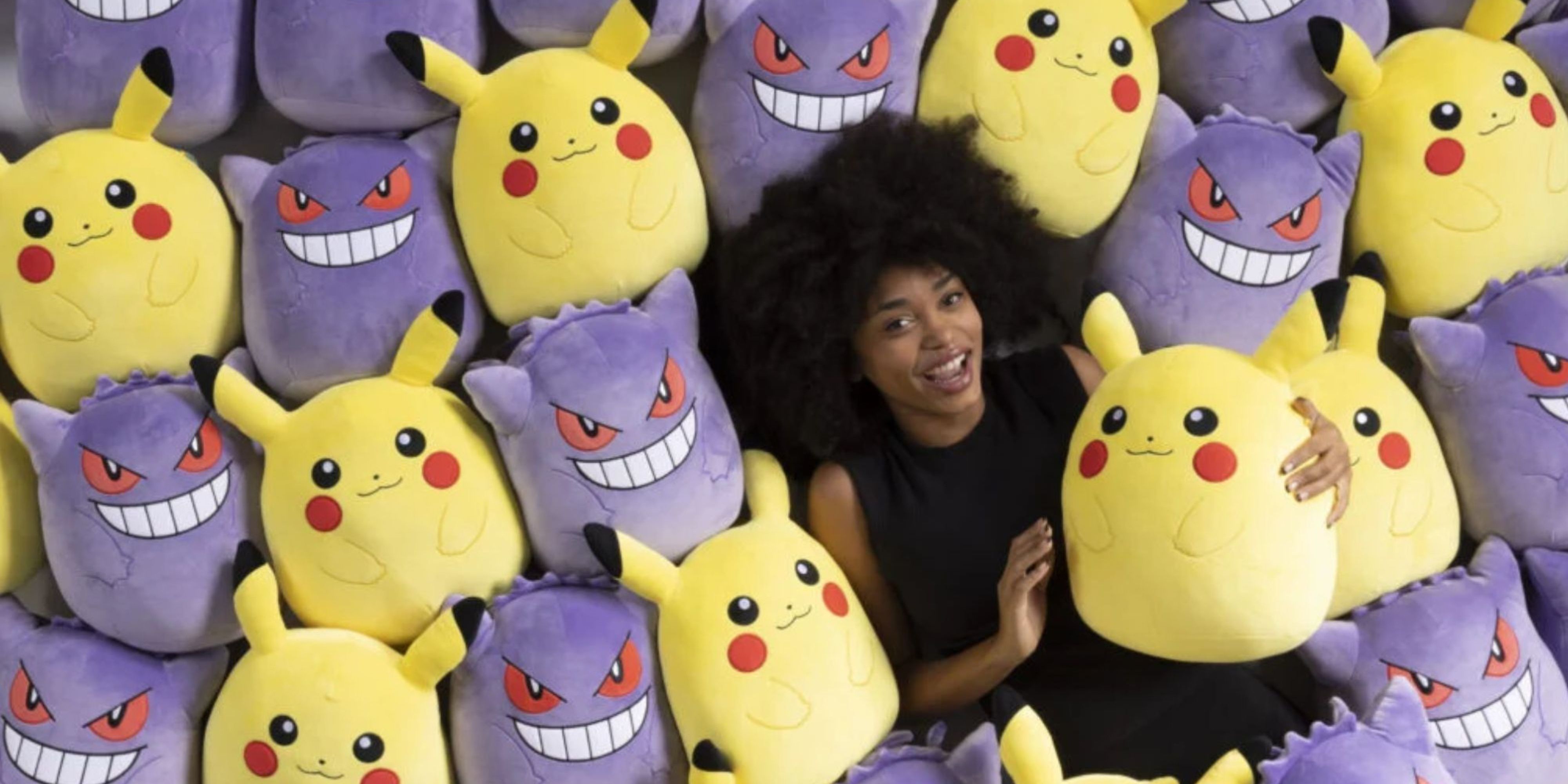 woman in a pile of pikachu and gengar pokemon squishmallows