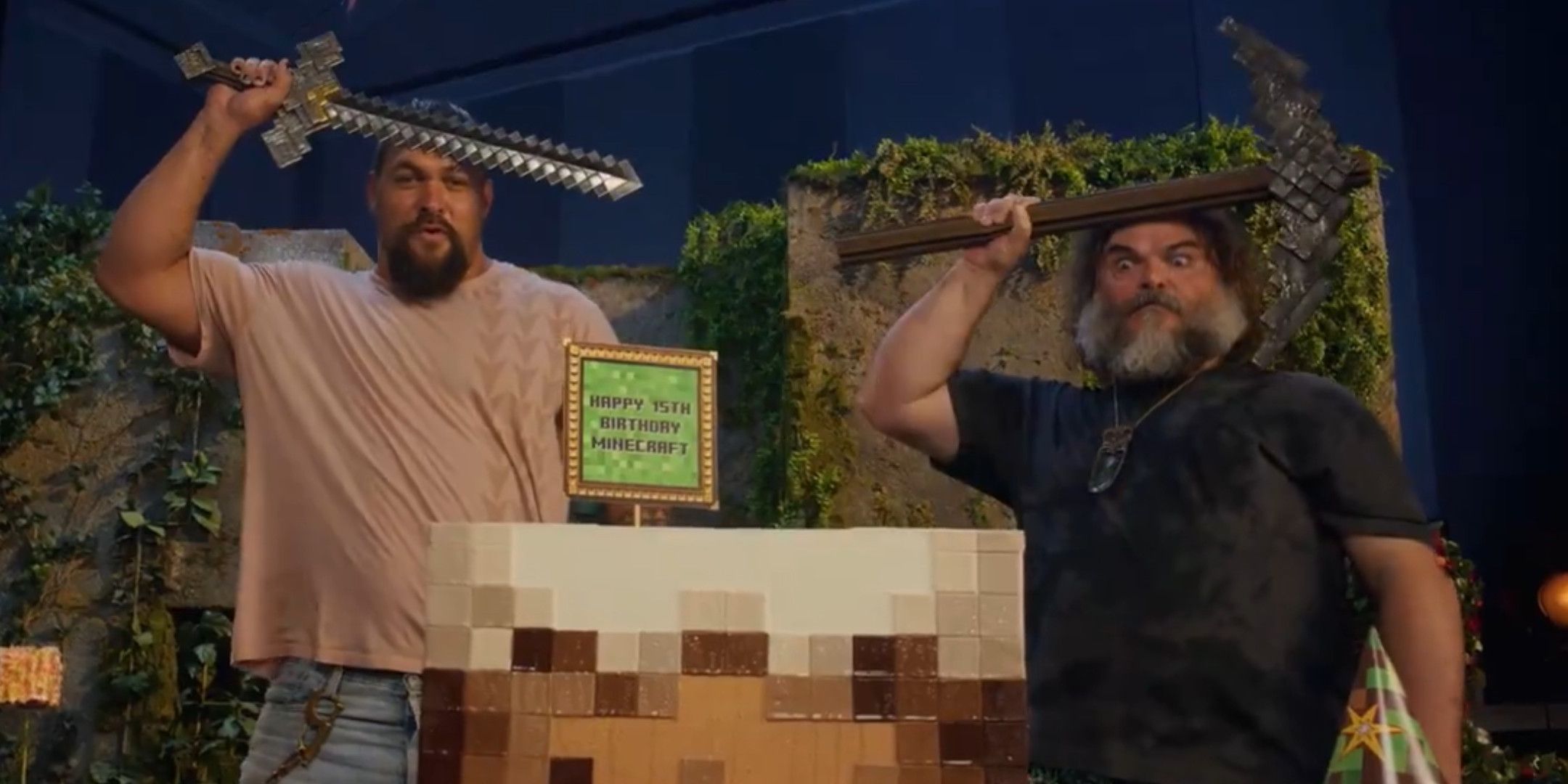 Jason Momoa and Jack Black holding a Minecraft pickaxe and sword in front of a cake-2