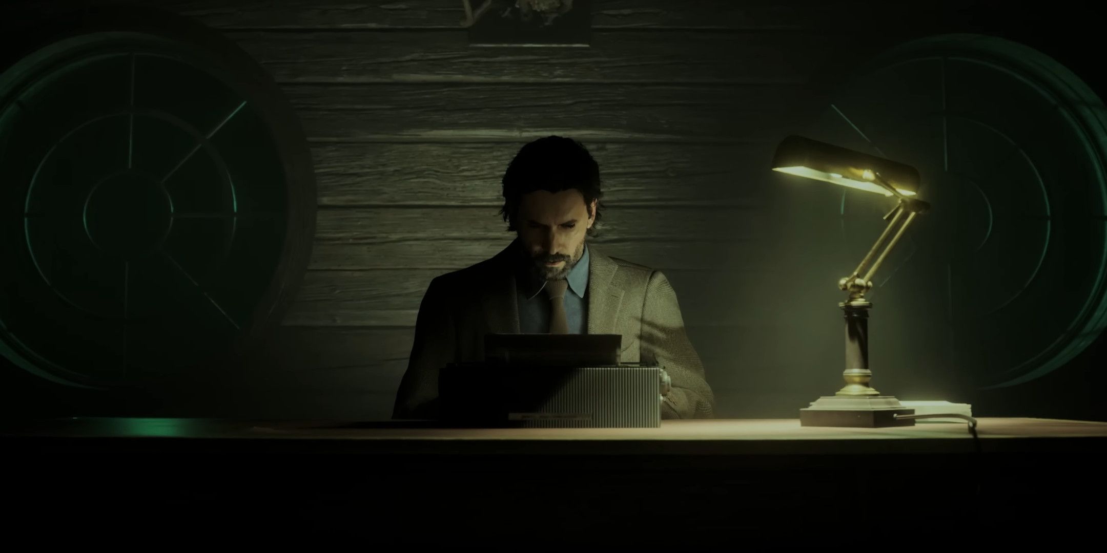 Alan Wake typing at a typewriter on a desk in a dark room