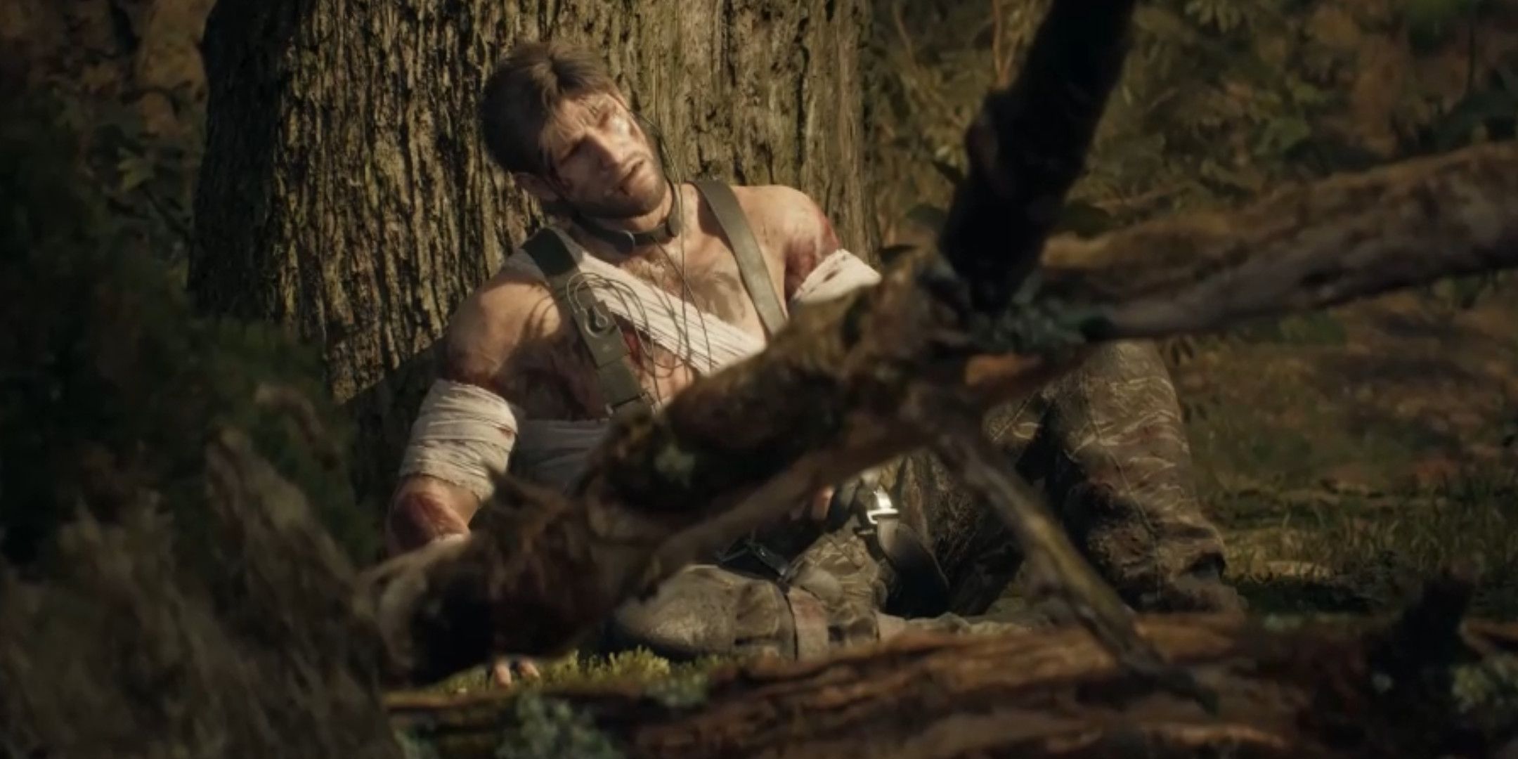 Snake leaning against a tree all bloodied and bandaged in Snake Eater