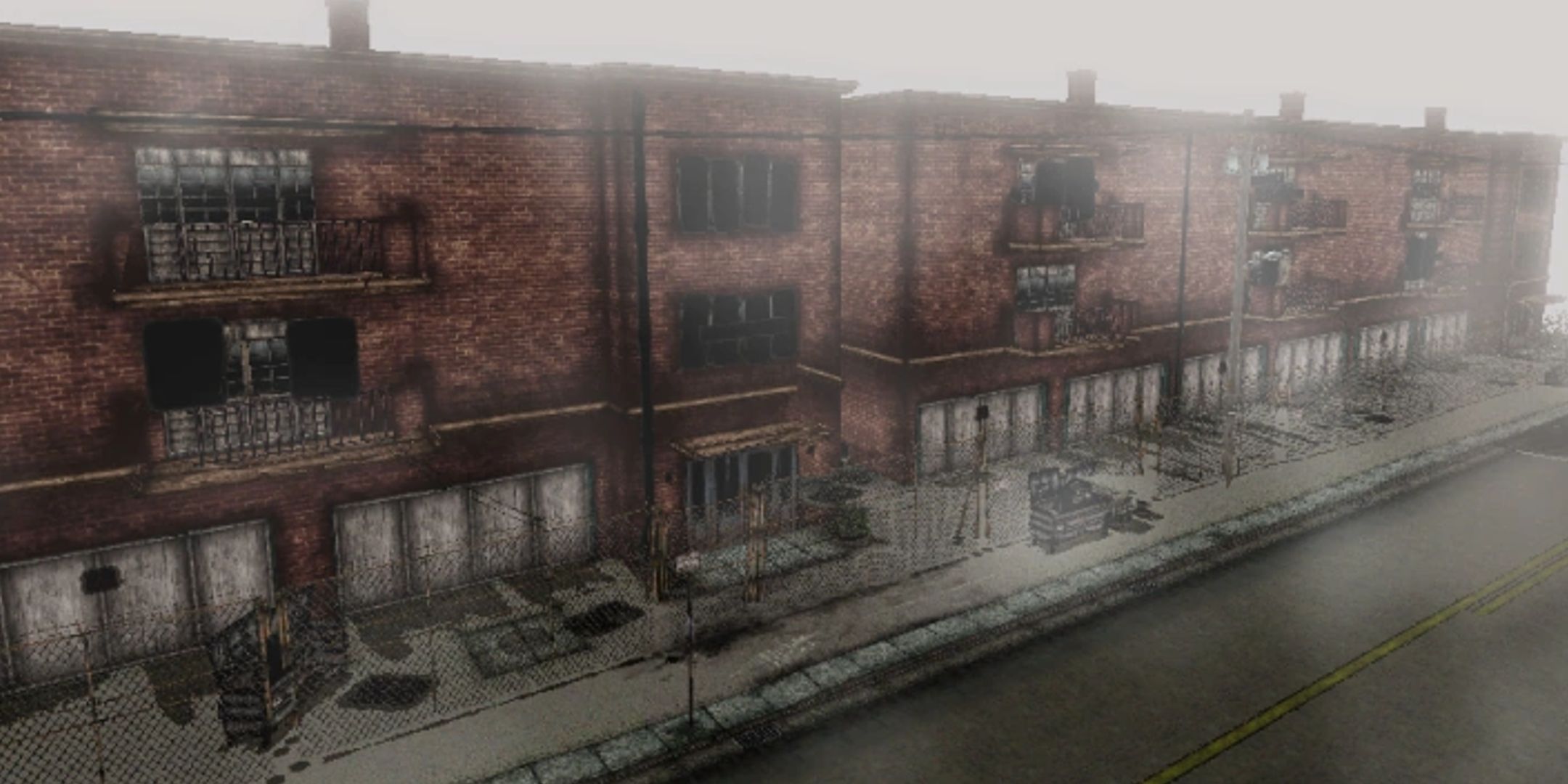 A red brick apartment complex is hauntingly empty, surrounded by fog.