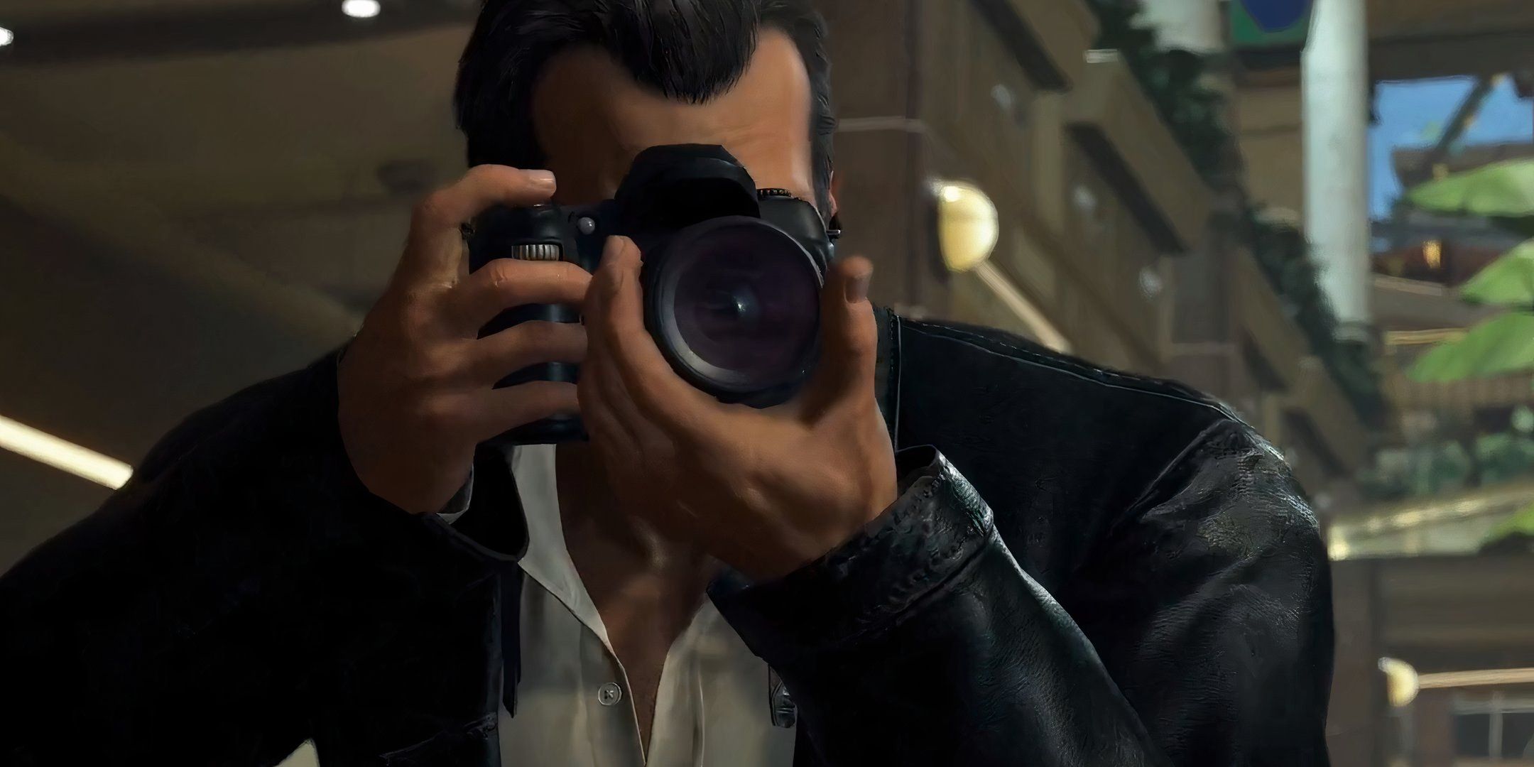 Frank West holds a camera in the Dead Rising Deluxe Remaster.