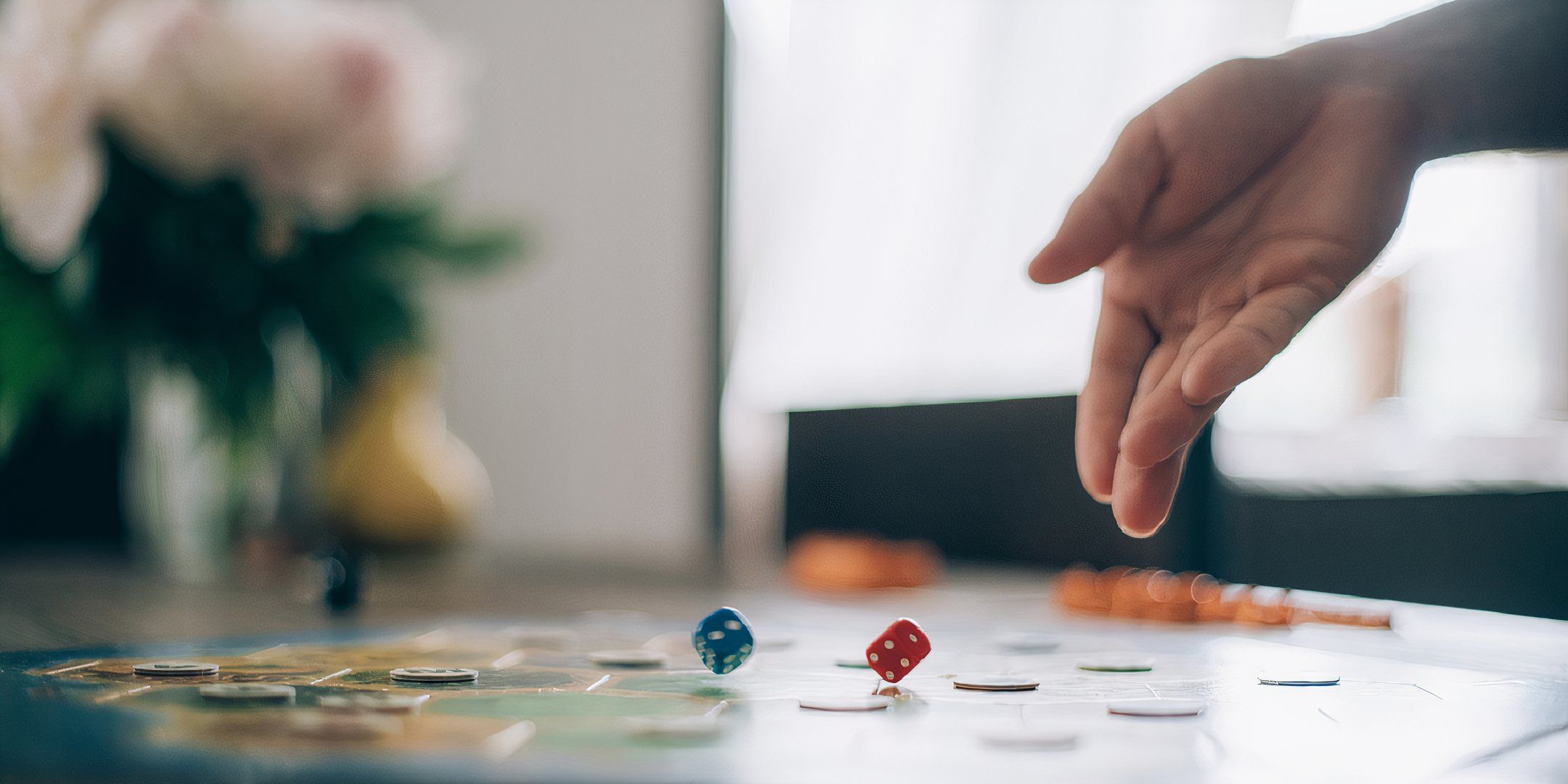 Hand throwing dice on game board