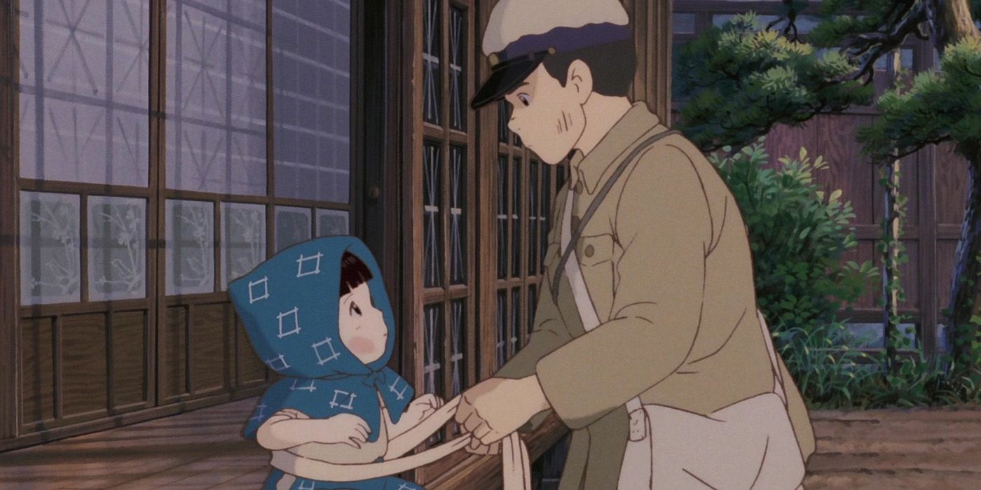 Seita, a teenager in the uniform of the Imperial Japanese Army, helps his younger sister Seita prepare for an air raid.