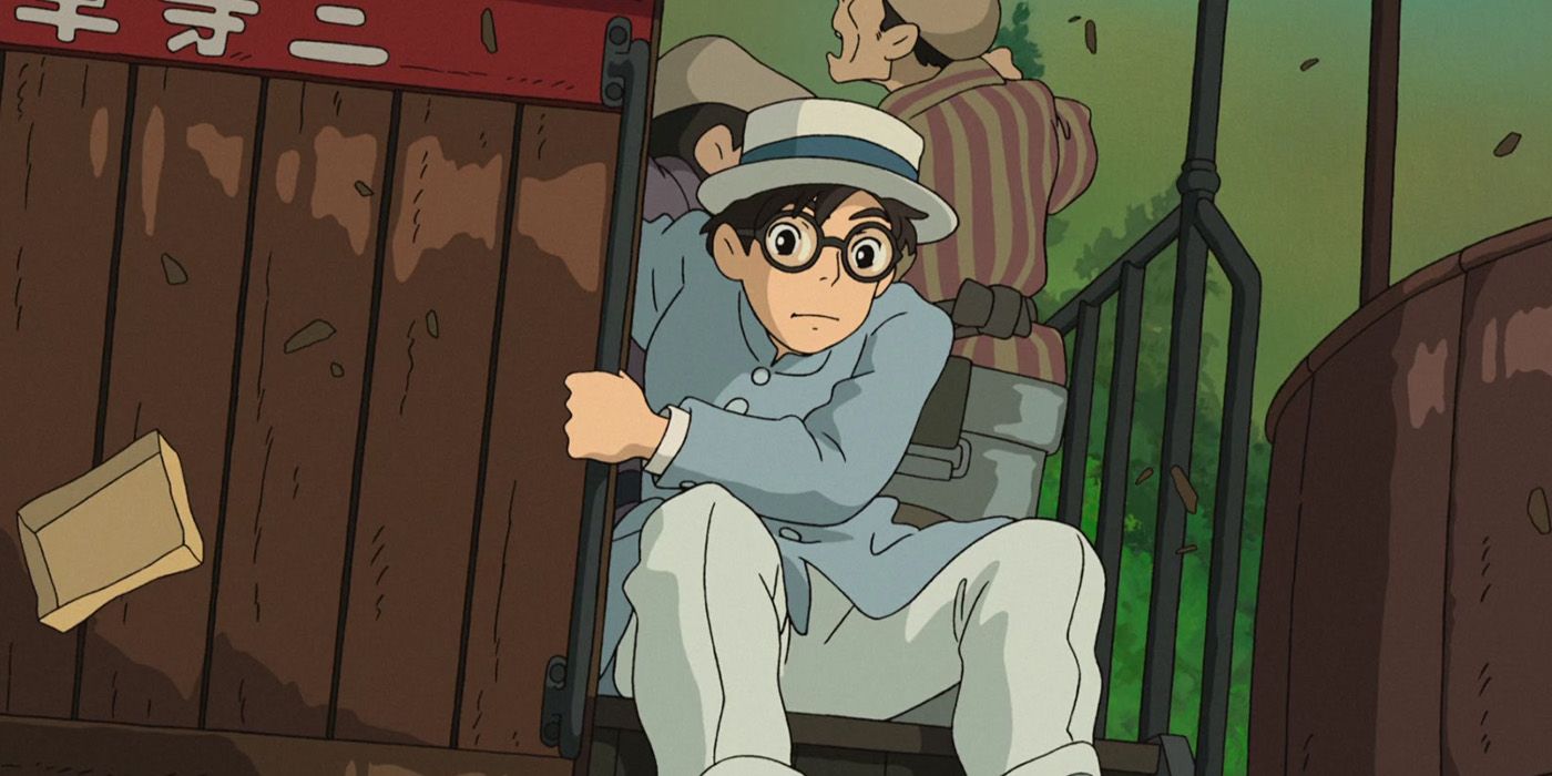 Jiro Horikoshi, wearing a white straw hat and light blue suit, clings to a railway carriage during the Great Kantō Earthquake of 1923.