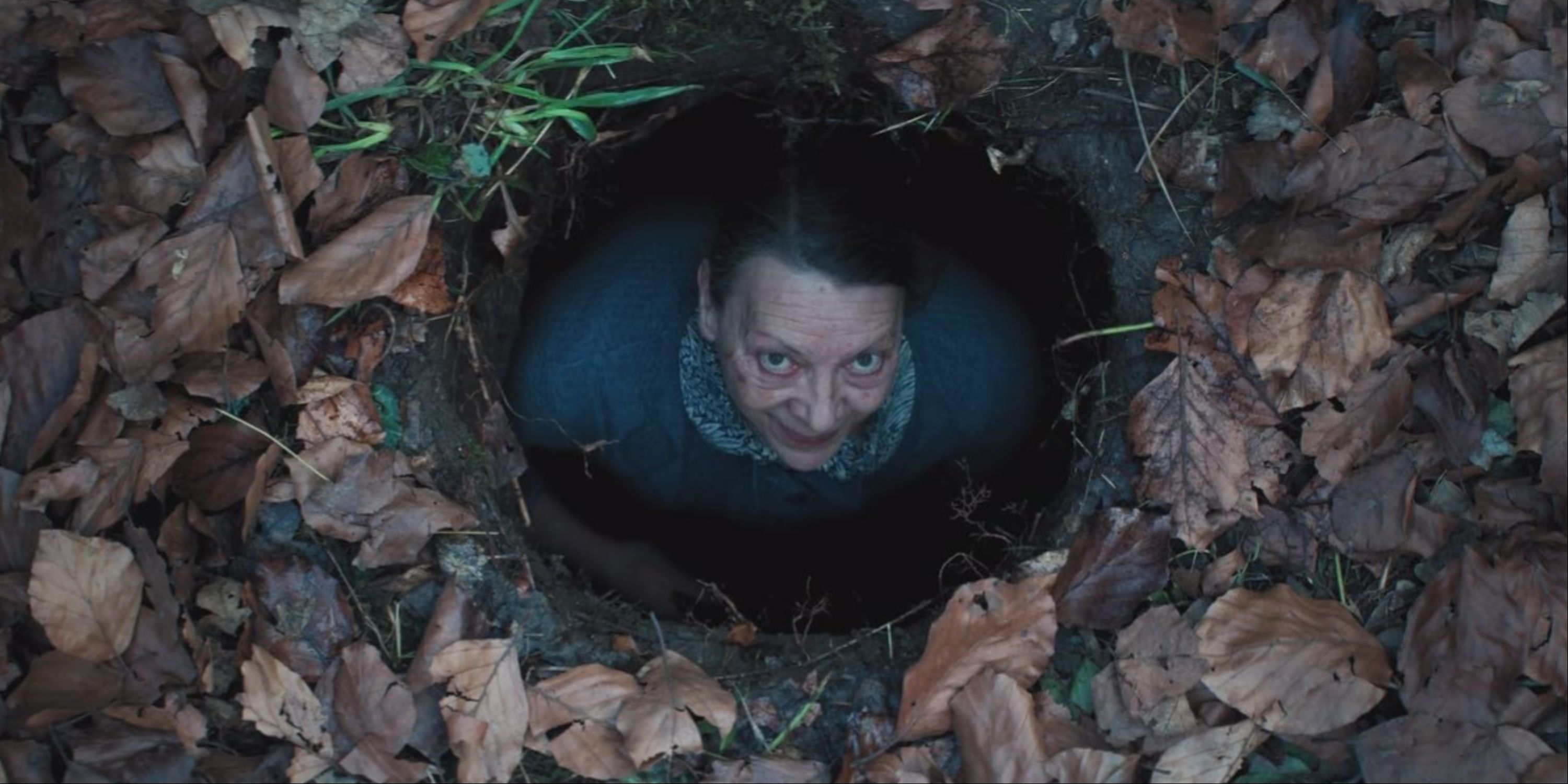 Madame Daugeron Looking Up At The Camera With A Creepy Expression In A Hole In The Ground In Marianne.