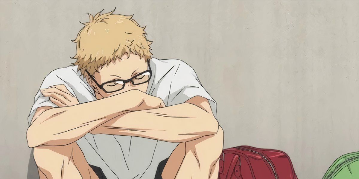 Kei Tsukishima slumped against a wall with his arms crossed in Haikyu.