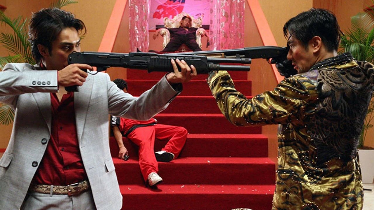 Kiryu and Majima pointing guns at eachother in Like a Dragon 2007.