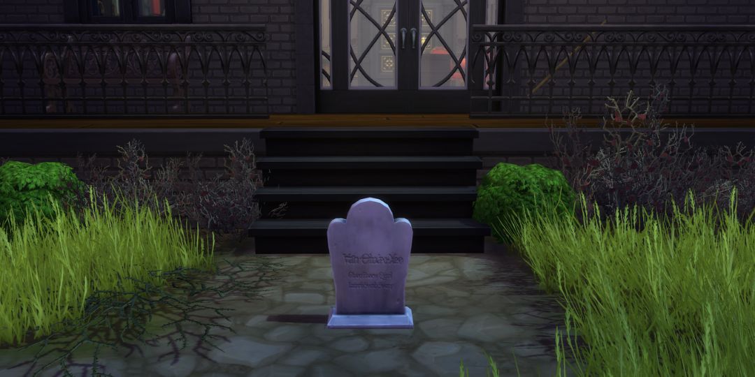 A very plain gravestone sits on a ground in front of some steps.