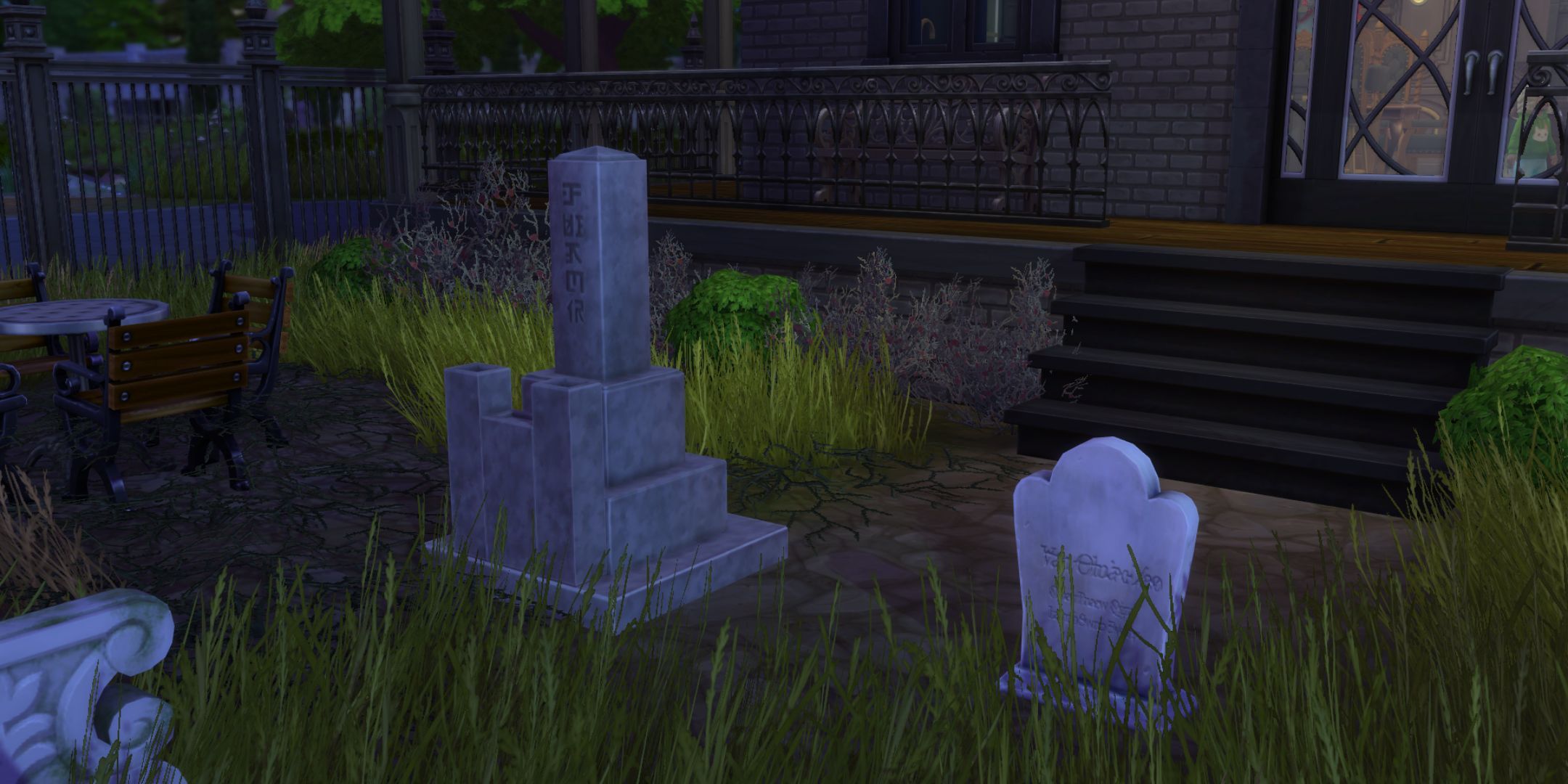 Two graves sit in a garden. One is ornate and looks like a pyramid while the other is a simple stone.