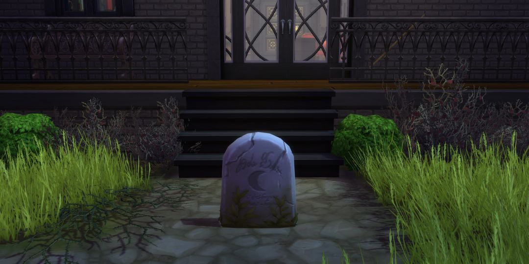 A worn and aged gravestone with a moon carved into the center.