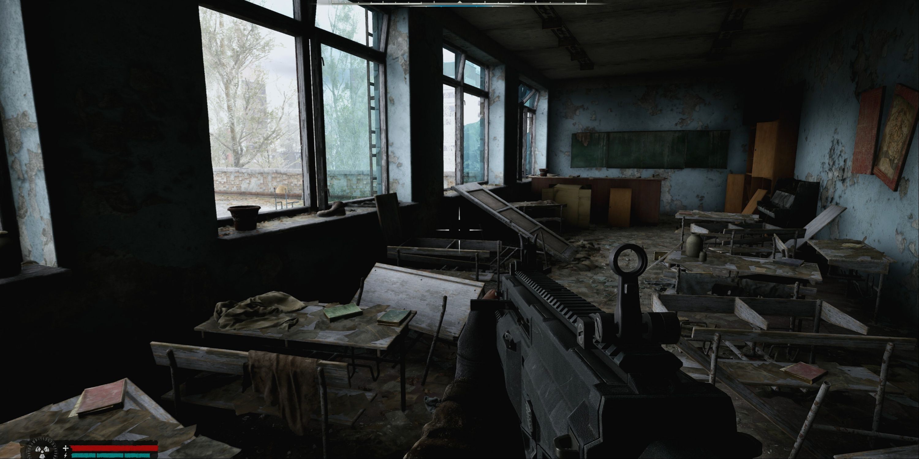 Stalker 2 - The player holding an assault rifle and walking through an abandoned, war-torn classroom, with the health UI visible in the bottom corner.