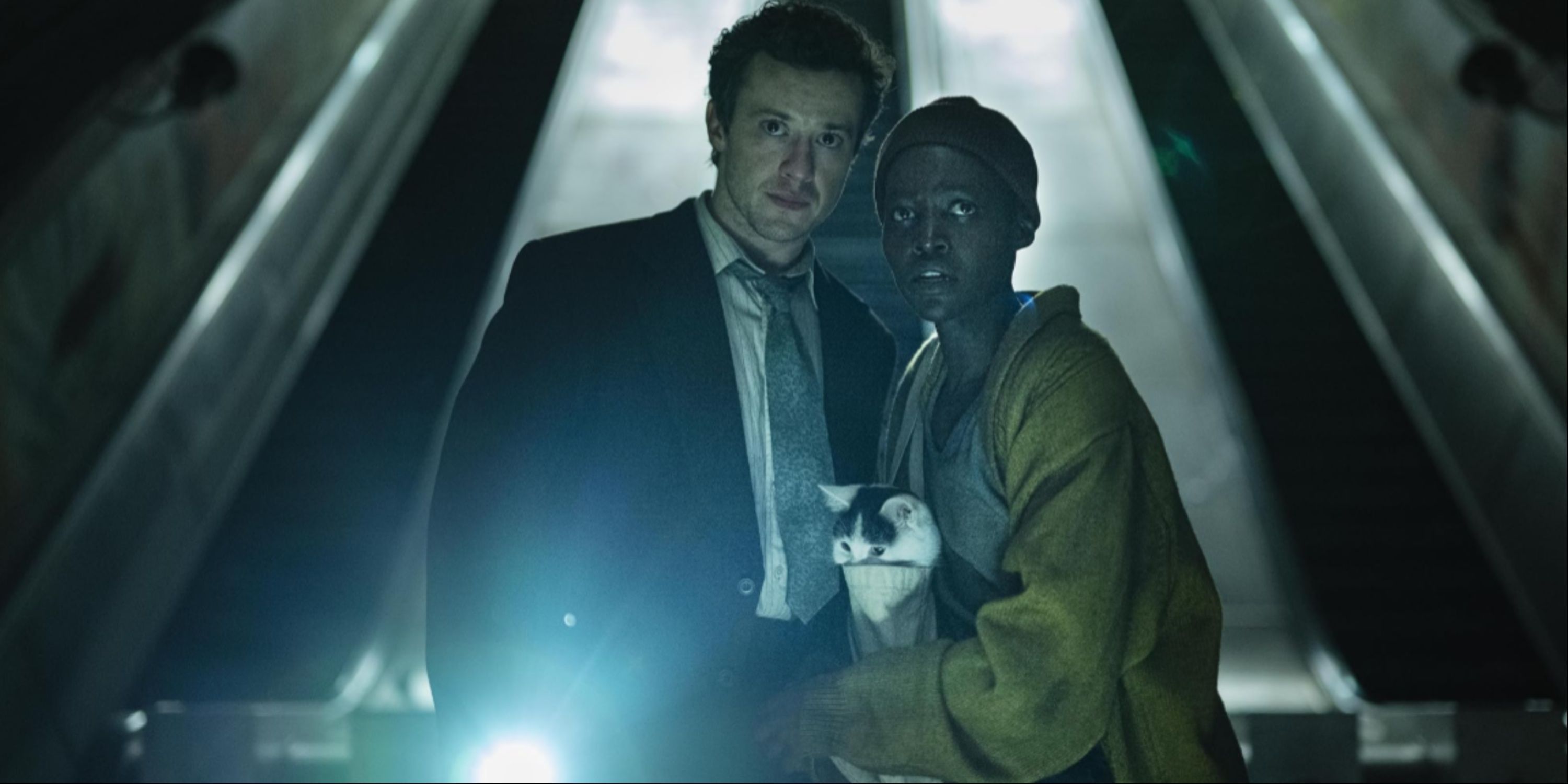 Joseph Quinn and Lupita Nyong'o with their cat in the dark subway tunnels in A Quiet Place Day One.