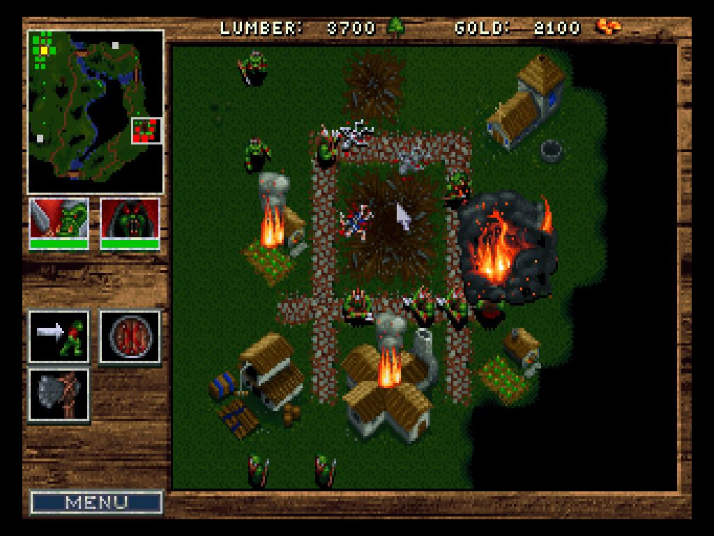 A screenshot from Warcraft: Orcs and Humans. It shows a town set on fire, attacked by orcs.