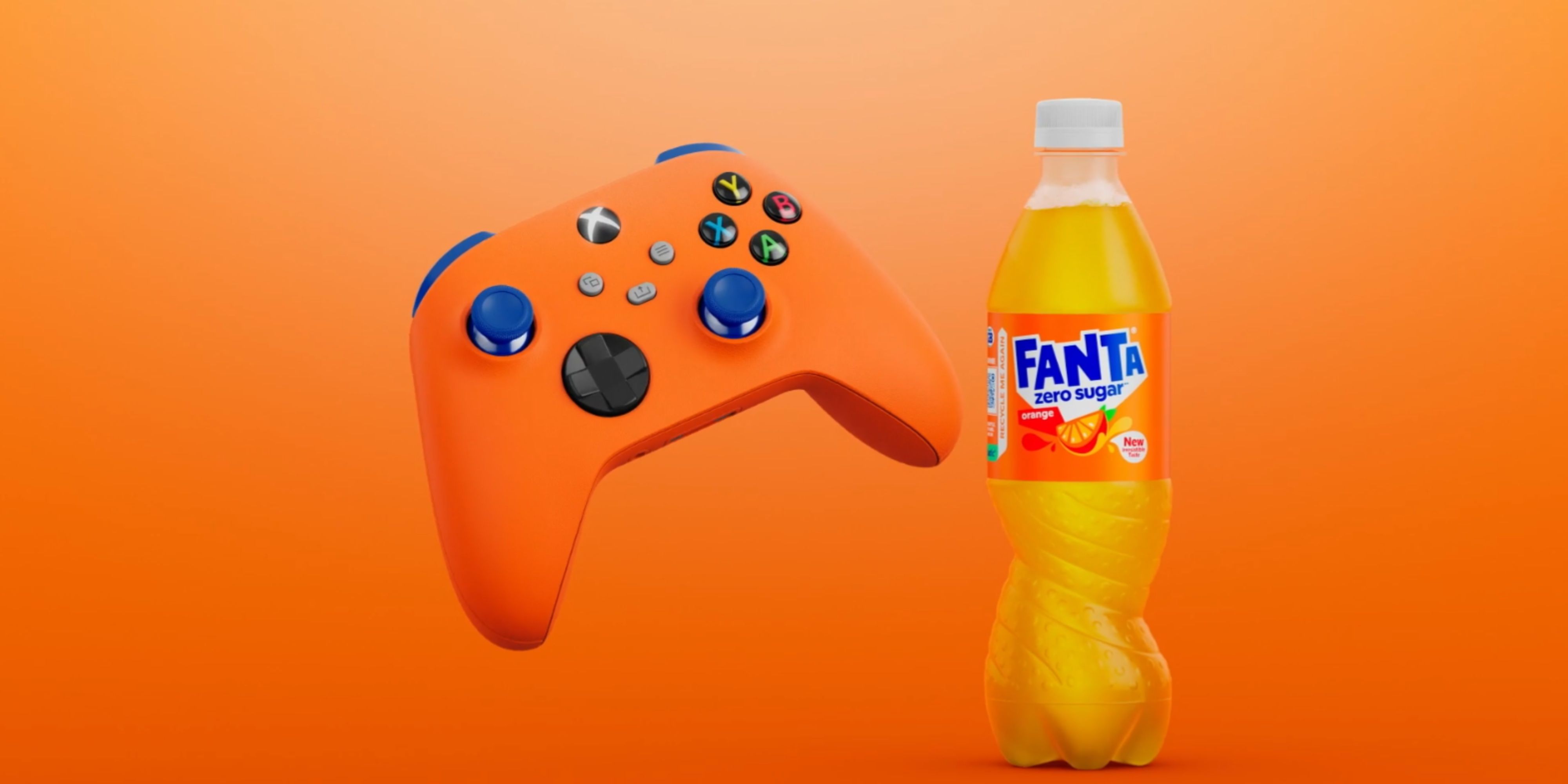 orange xbox controller next to a bottle of orange fanta.