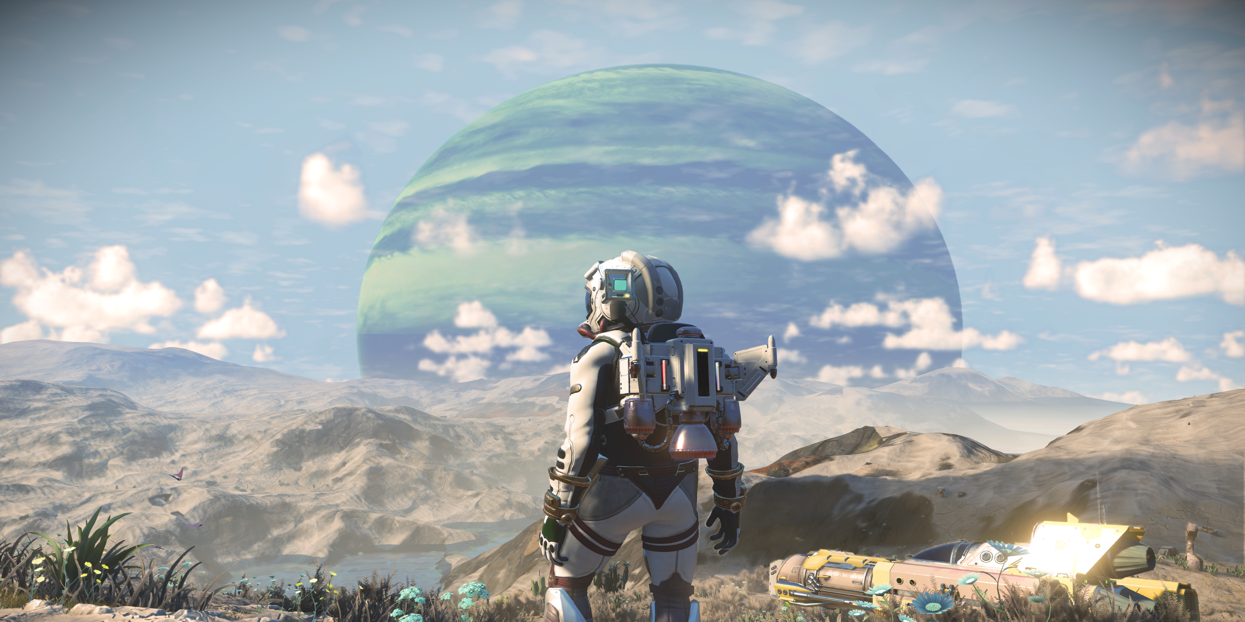 An astronaut looking off into the distance, with a large planet close in the background in No Man's Sky.
