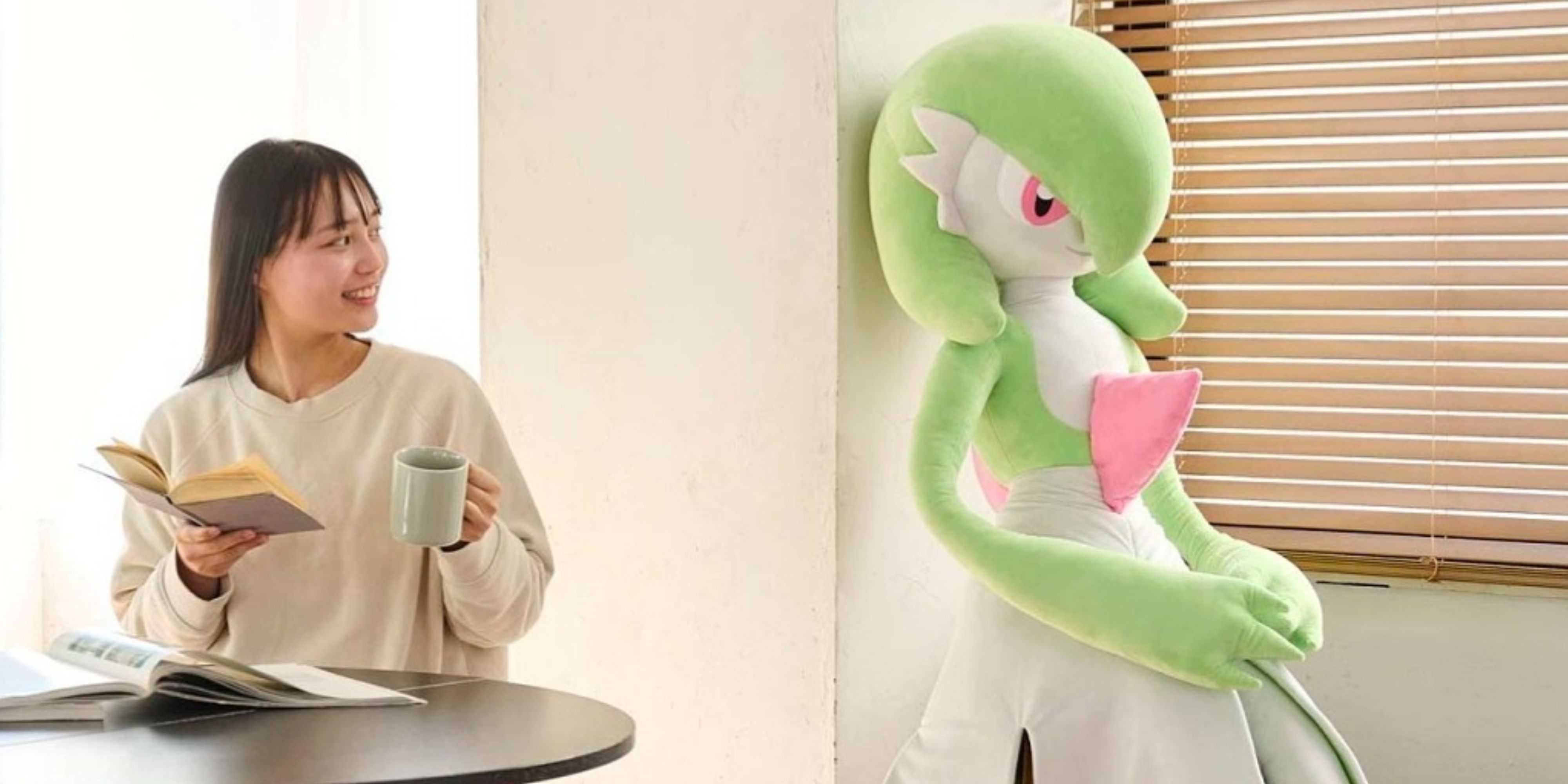 someone looking lovingly at their life size gardevoir plush over morning coffee.