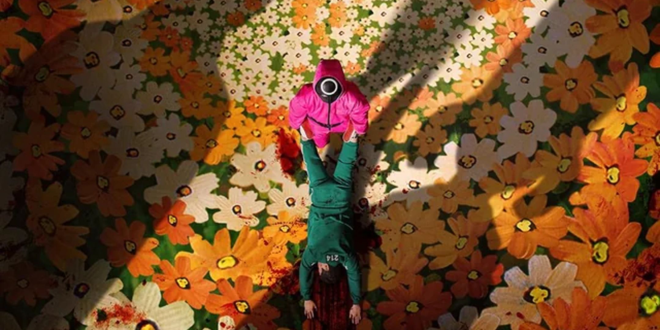 A guard drags a player's body in a field of flowers in Squid Game. 