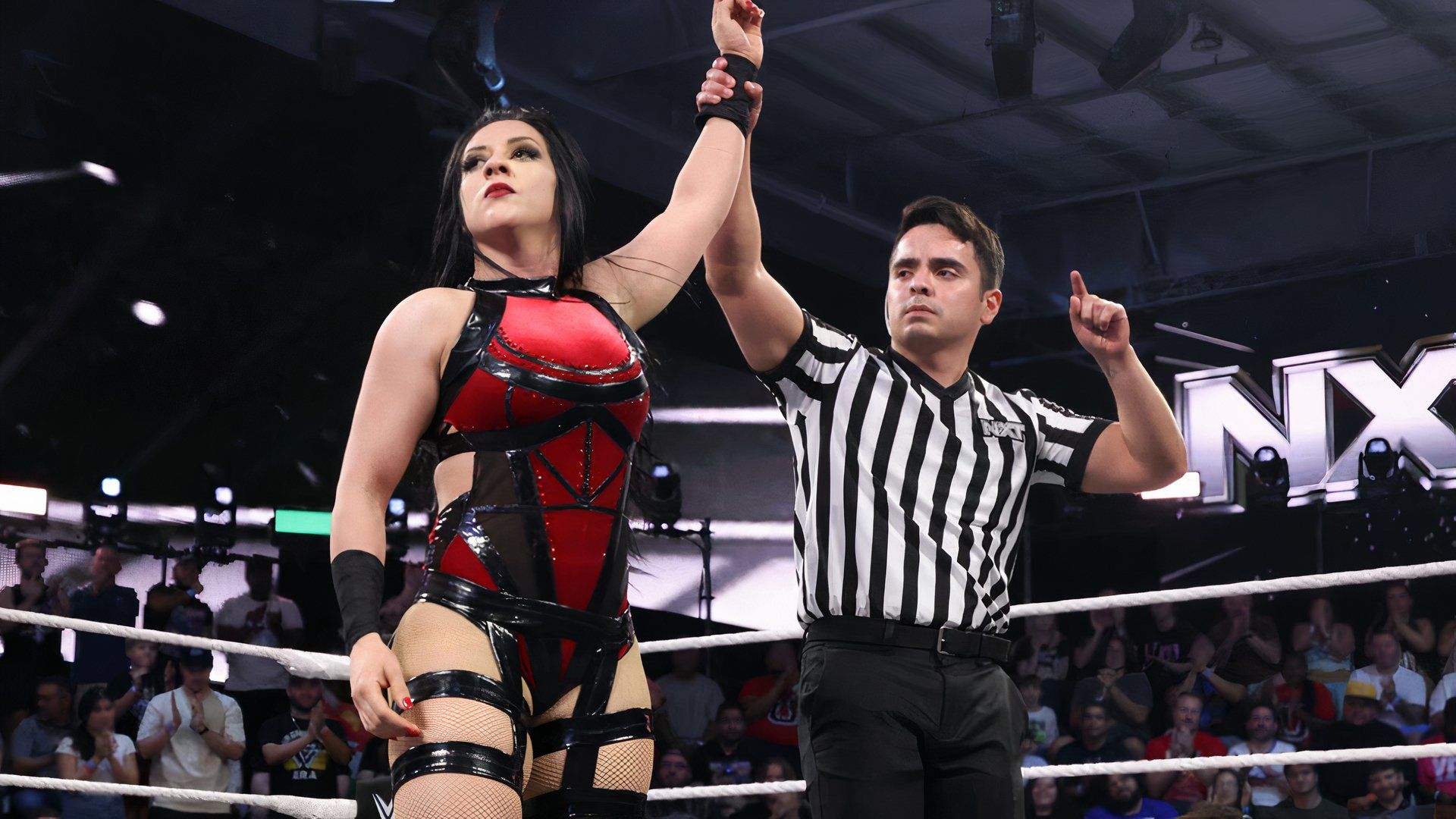 A referee raises Stephanie Vaquer's hand after she wins a match on WWE NXT.