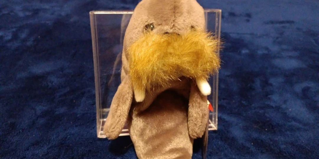 A walrus sits on a blue plush blanket