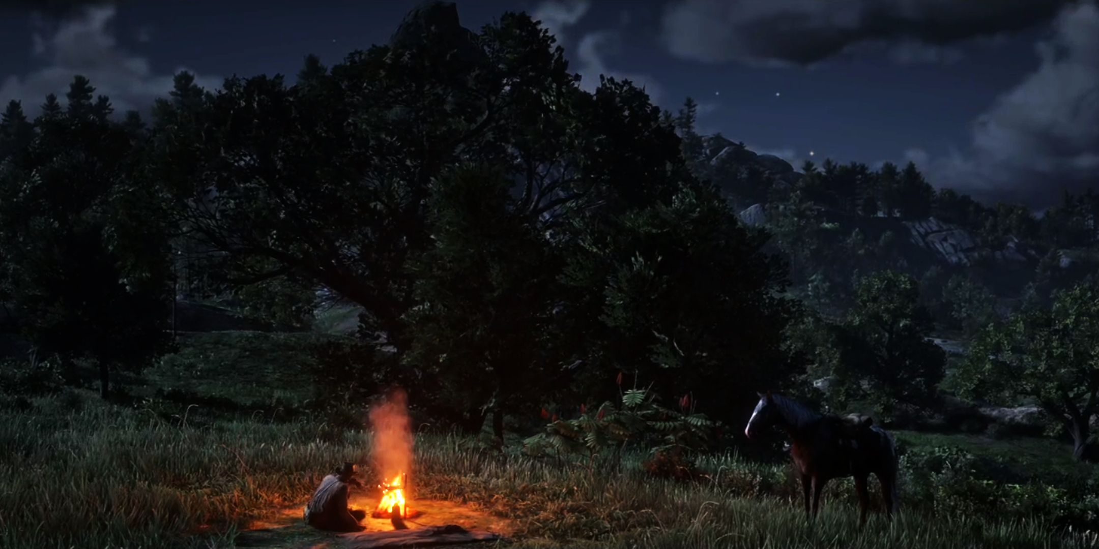 RDR 2 Arthur sits near the campfire at night