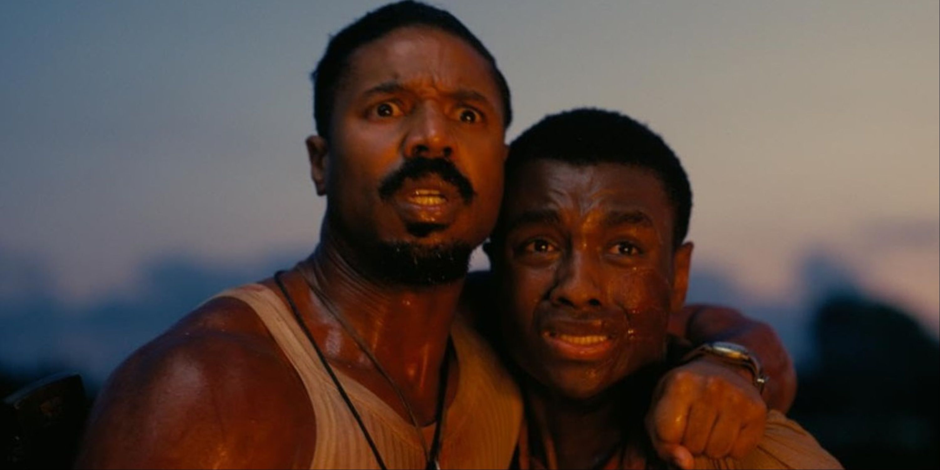 Michael B Jordan as Smoke and Miles Caton as Sammie looking at Remmick burning into flames at the end of Sinners.
