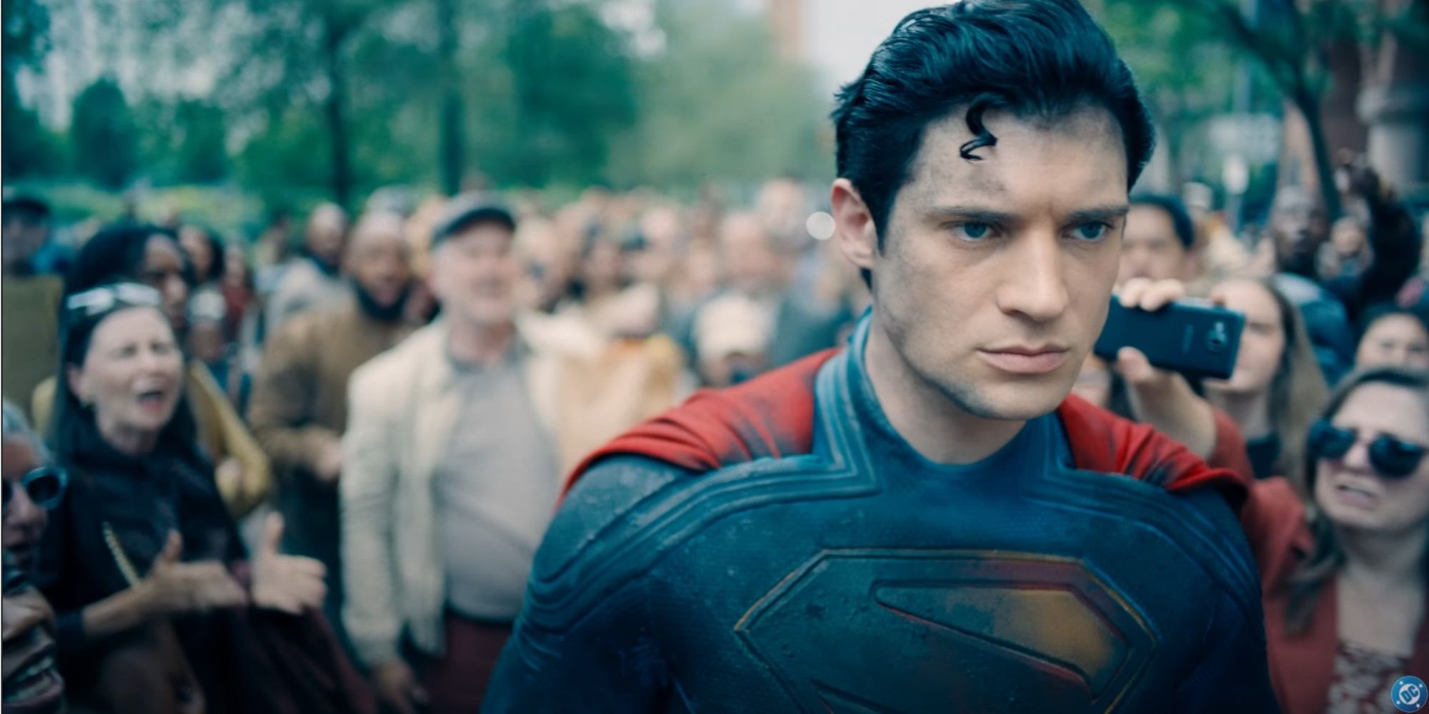 Superman looking defeated a a crowd heckles him in the background.