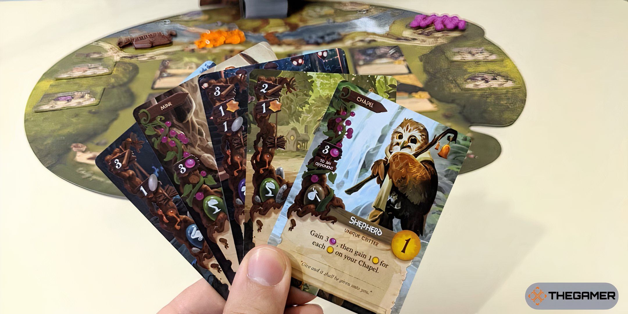 A player holding a card set in his hand for Everdell.
