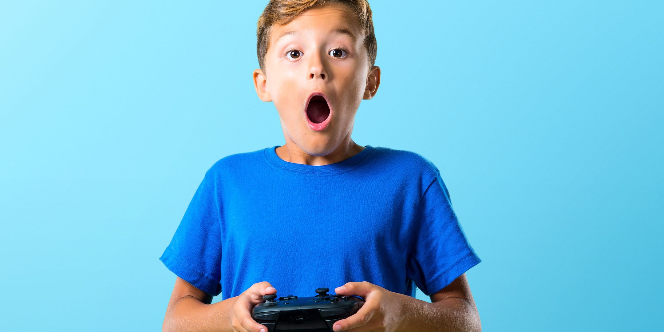Kid holding a video game controller looking shocked.