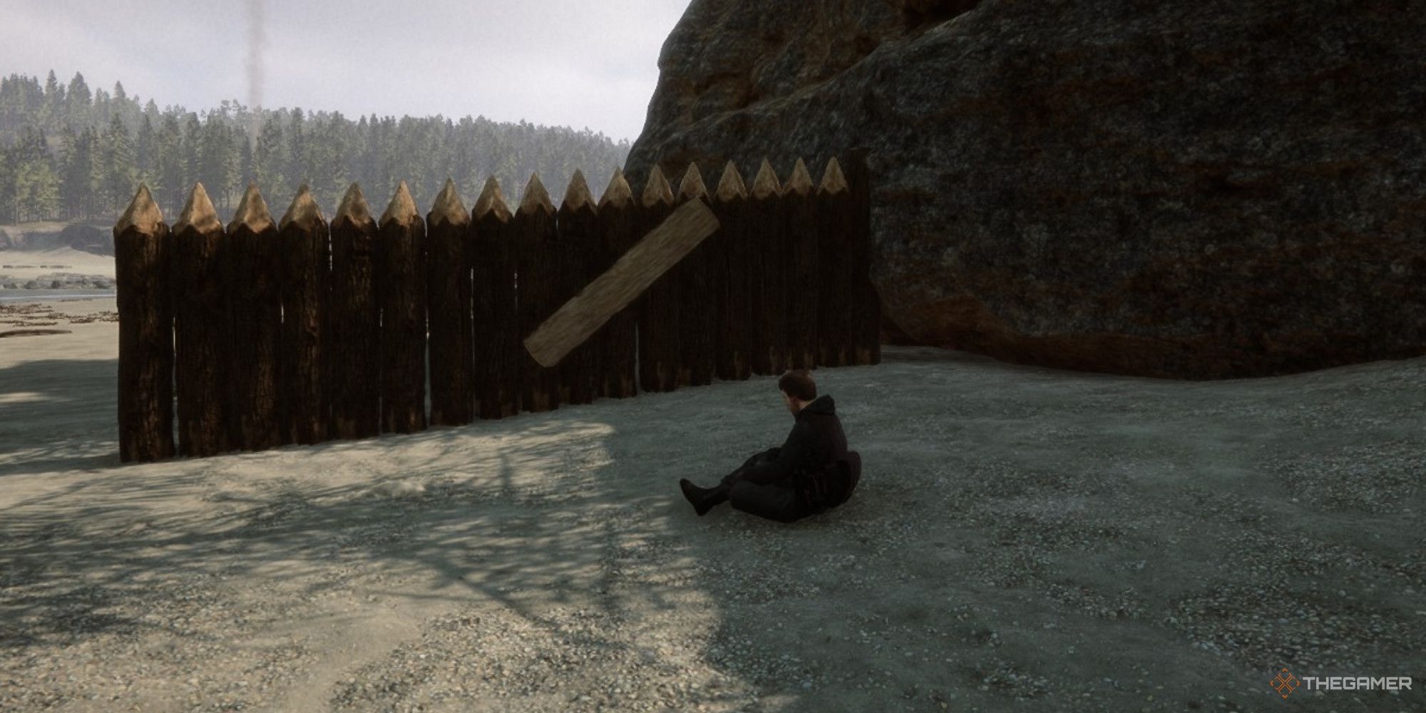 A screenshot from Sons of the Forest showing Kelvin sitting in front of a defensive wall with a gate opening on the beach.