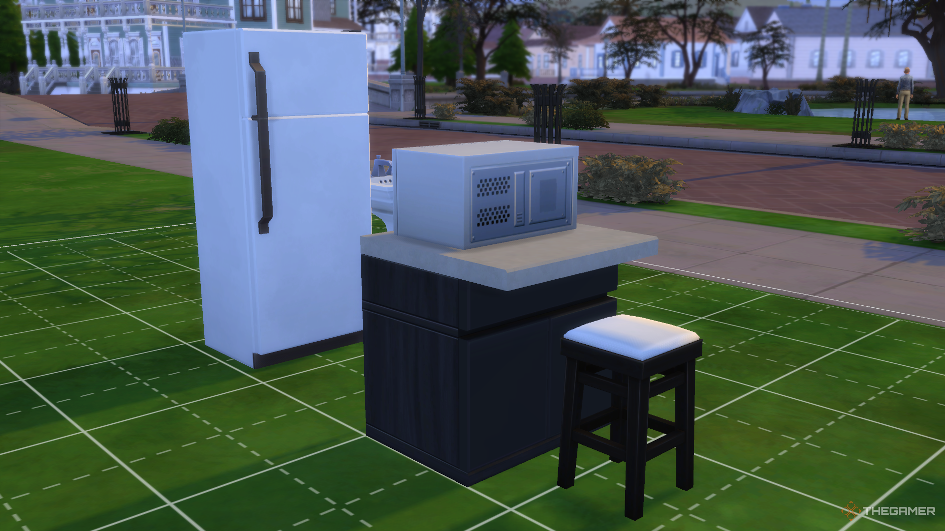 Kitchen furniture and appliances arranged on the front lawn next to the street in The Sims 4.