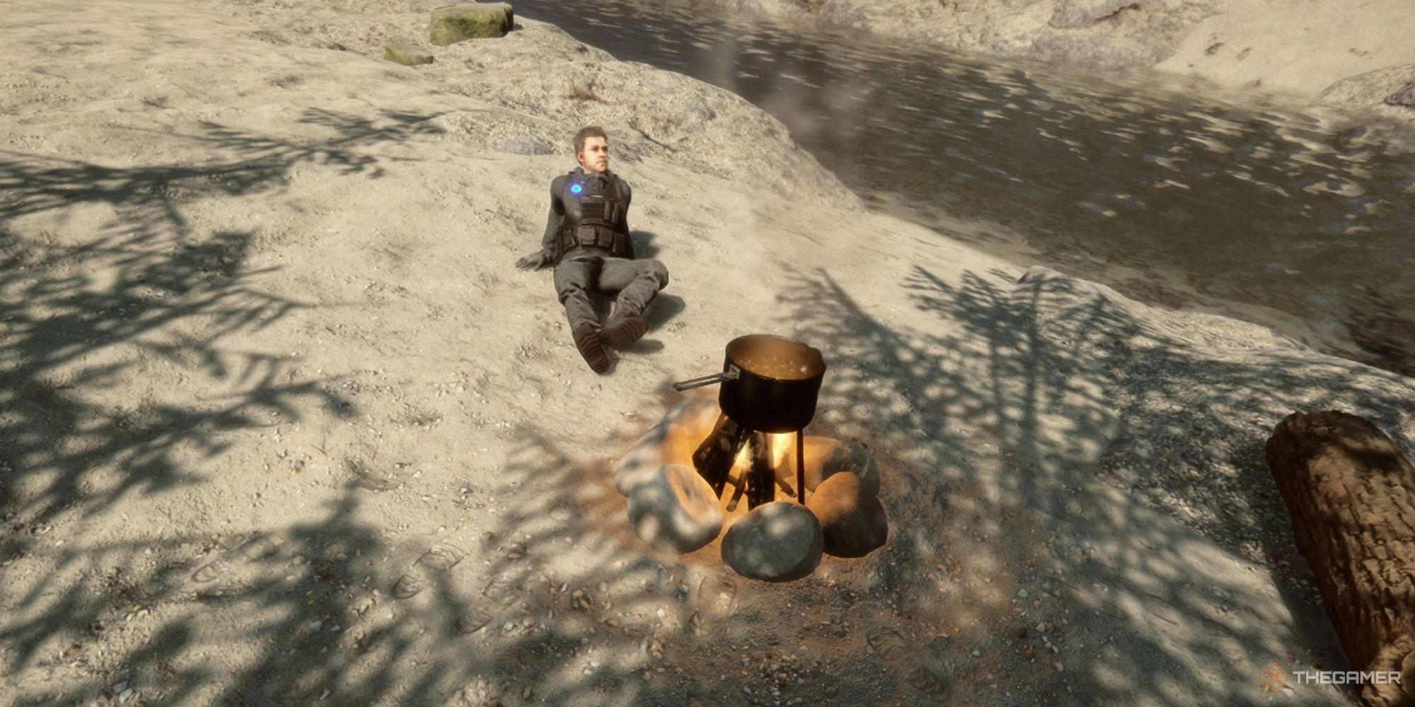 A screenshot from Sons of the Forest showing Kelvin relaxing by a fire on a beach. The fire has an uncovered pot on top, with steam rising from the boiling water.