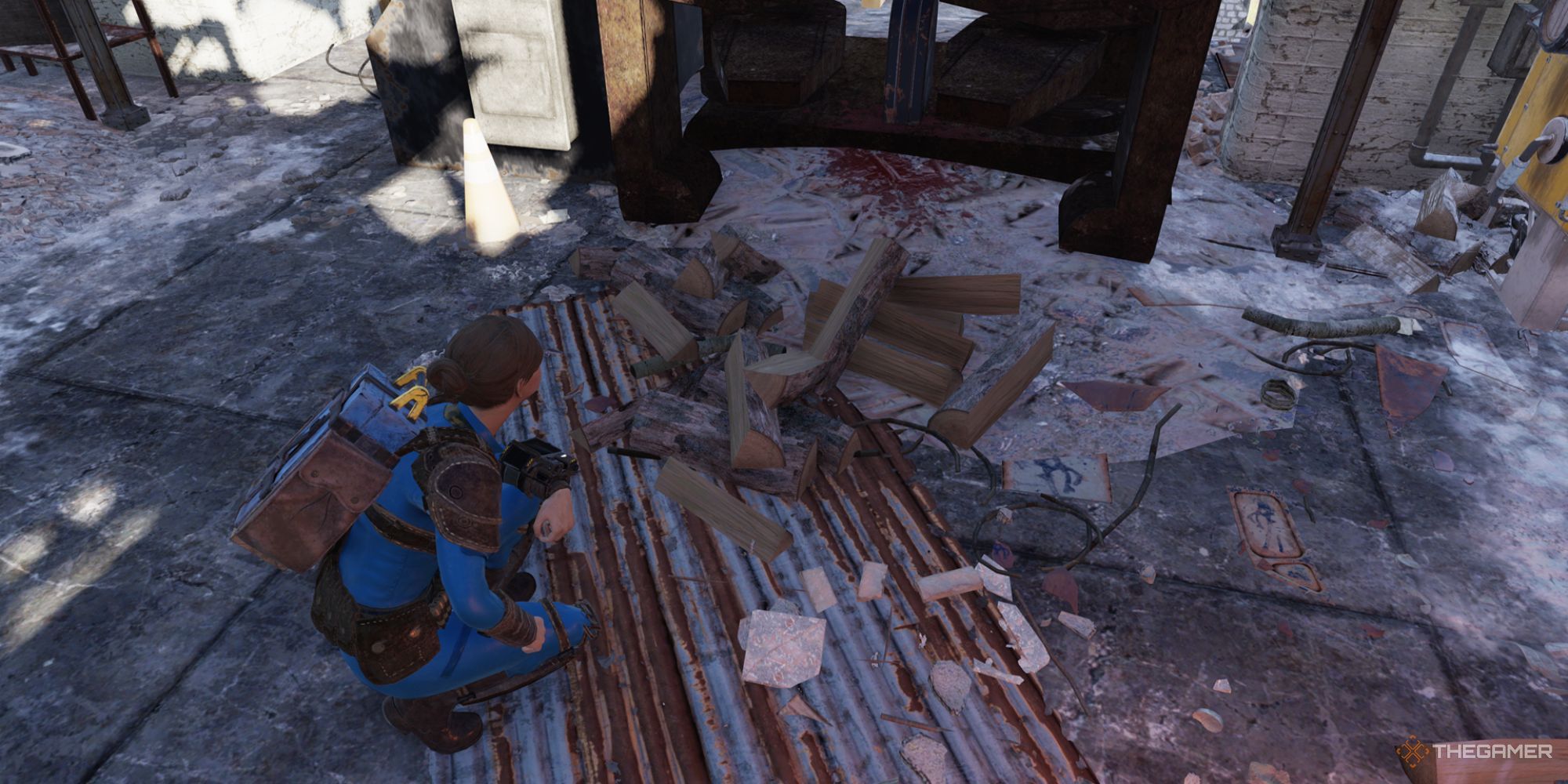 A player crouching near a scattered pile of wood inside the Gilman Lumber Mill in Fallout 76.