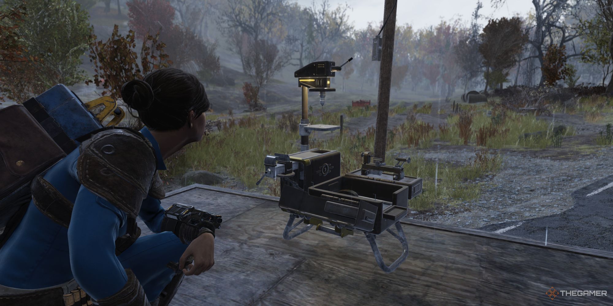 A player crouching near a CAMP device on the outskirts of Wixon Homestead in Fallout 76.