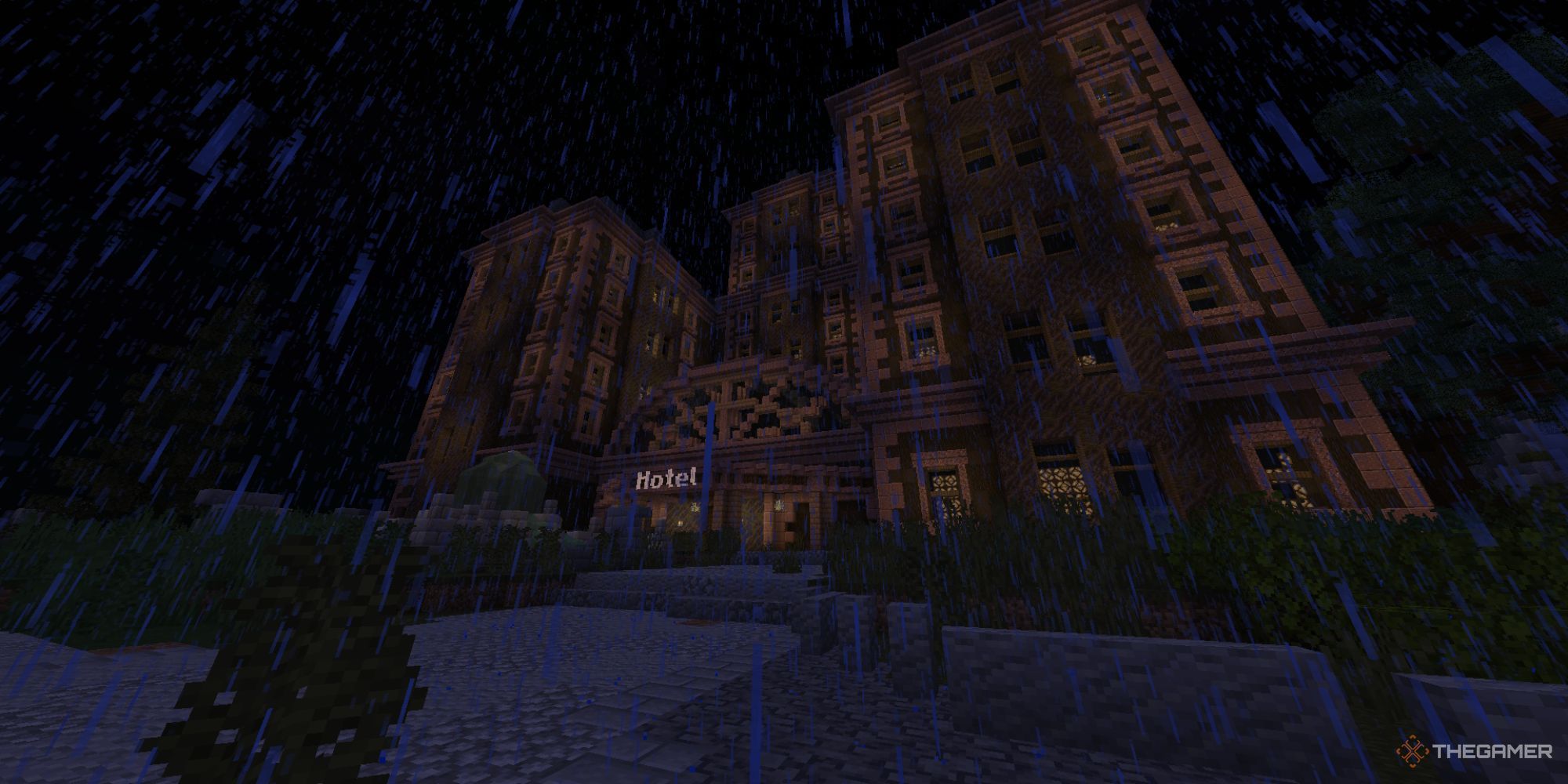 A dark, rainy screenshot of a tall, multistory hotel with the lights still on.