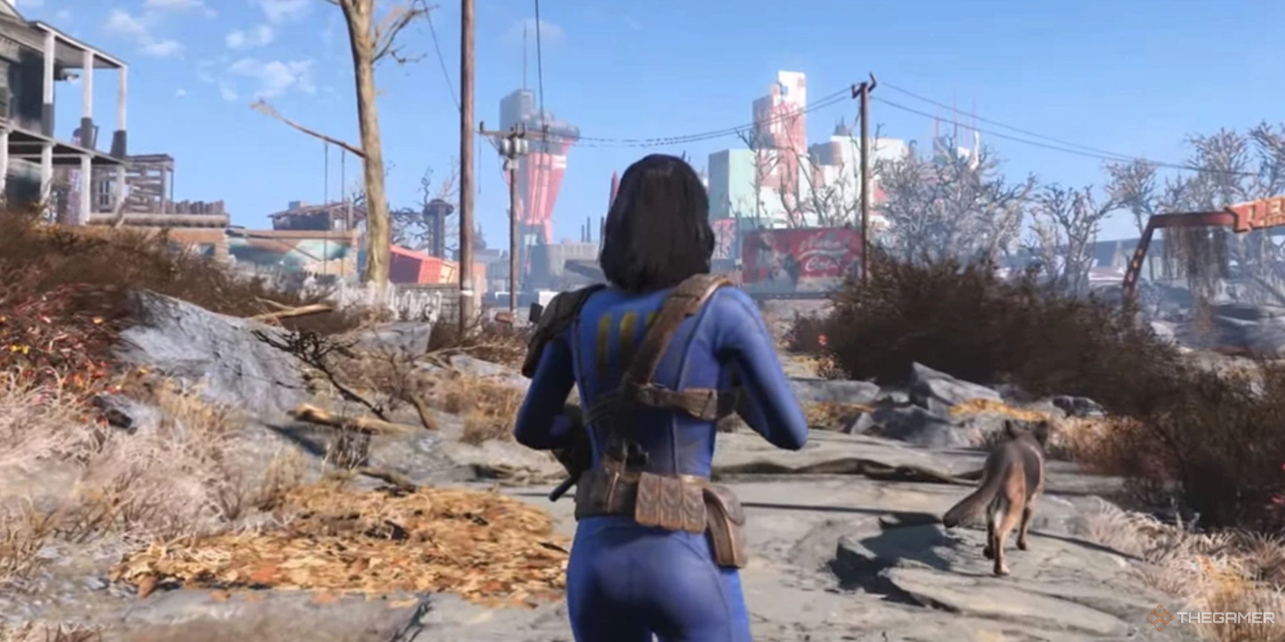 The female Sole Survivor from Fallout 4 heads down a broken road with her canine companion, Dogmeat. She's wearing a blue Vault 111 jumpsuit and armed with a rifle.