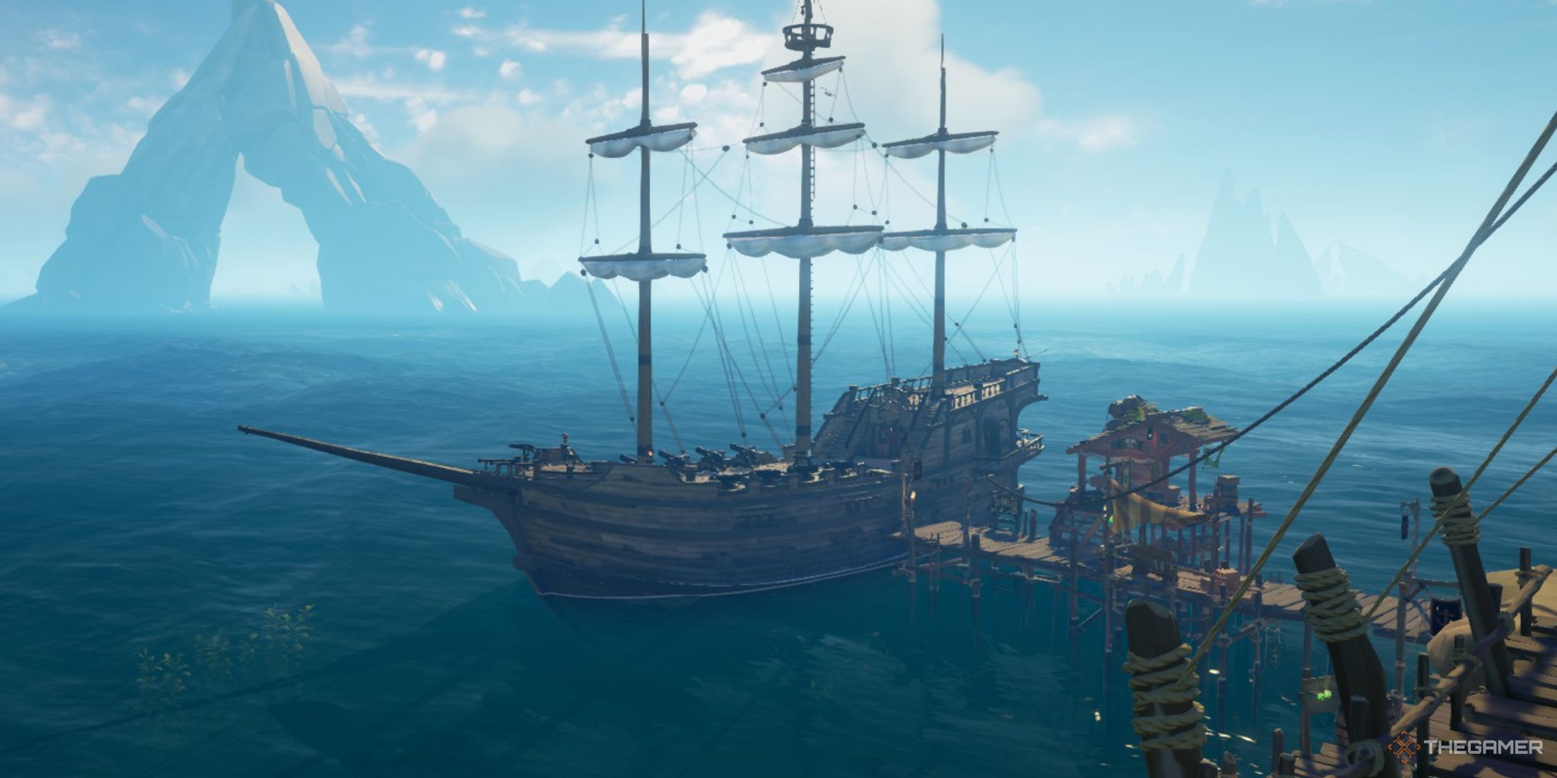 A screenshot from Sea of Thieves showing the Galleon ship docked with its sails raised.