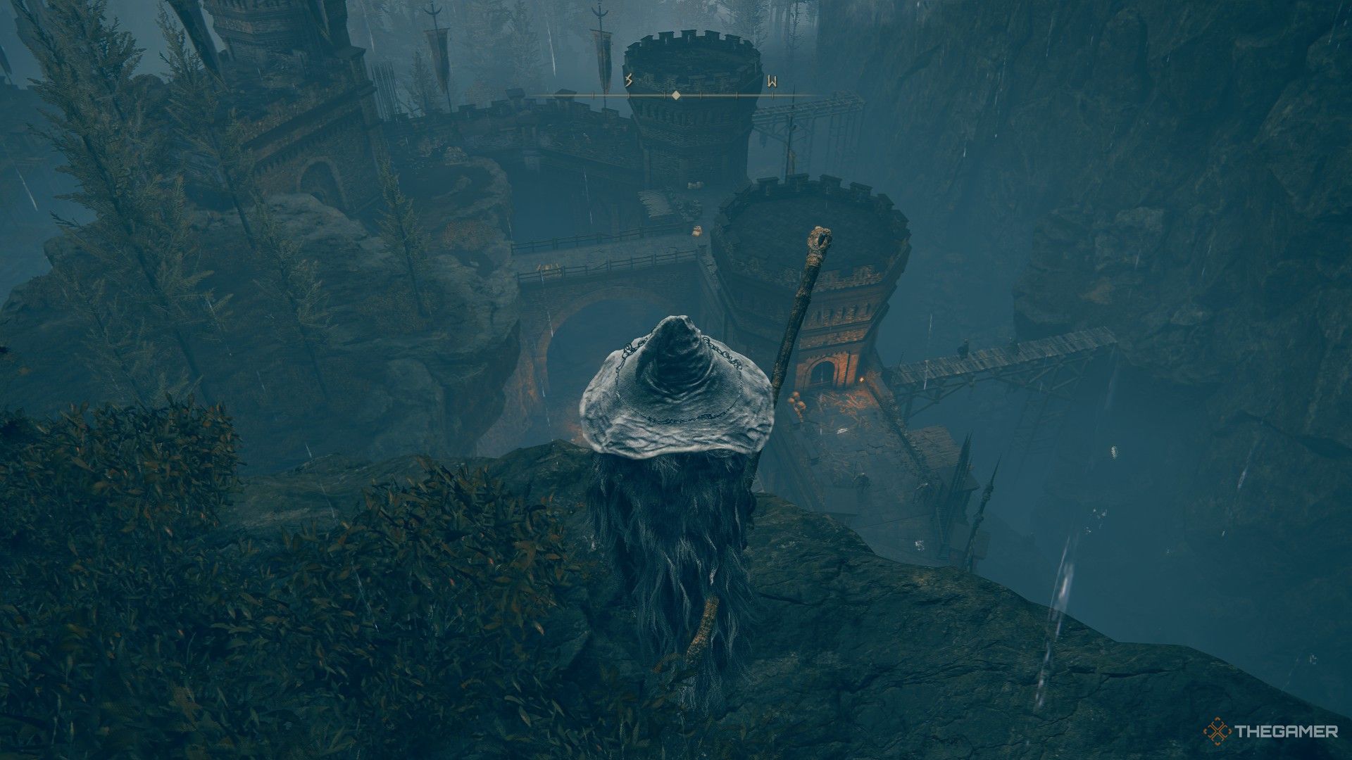 Player stands in the rain, inspecting the tops of Fog Rift Fort from an above ledge in Elden Ring: Shadow of the Erdtree.