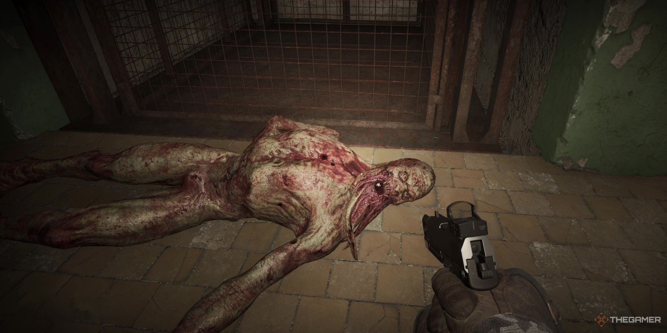 A Bloodsucker dead on the ground by a wall in Stalker 2 Heart of Chornobyl.