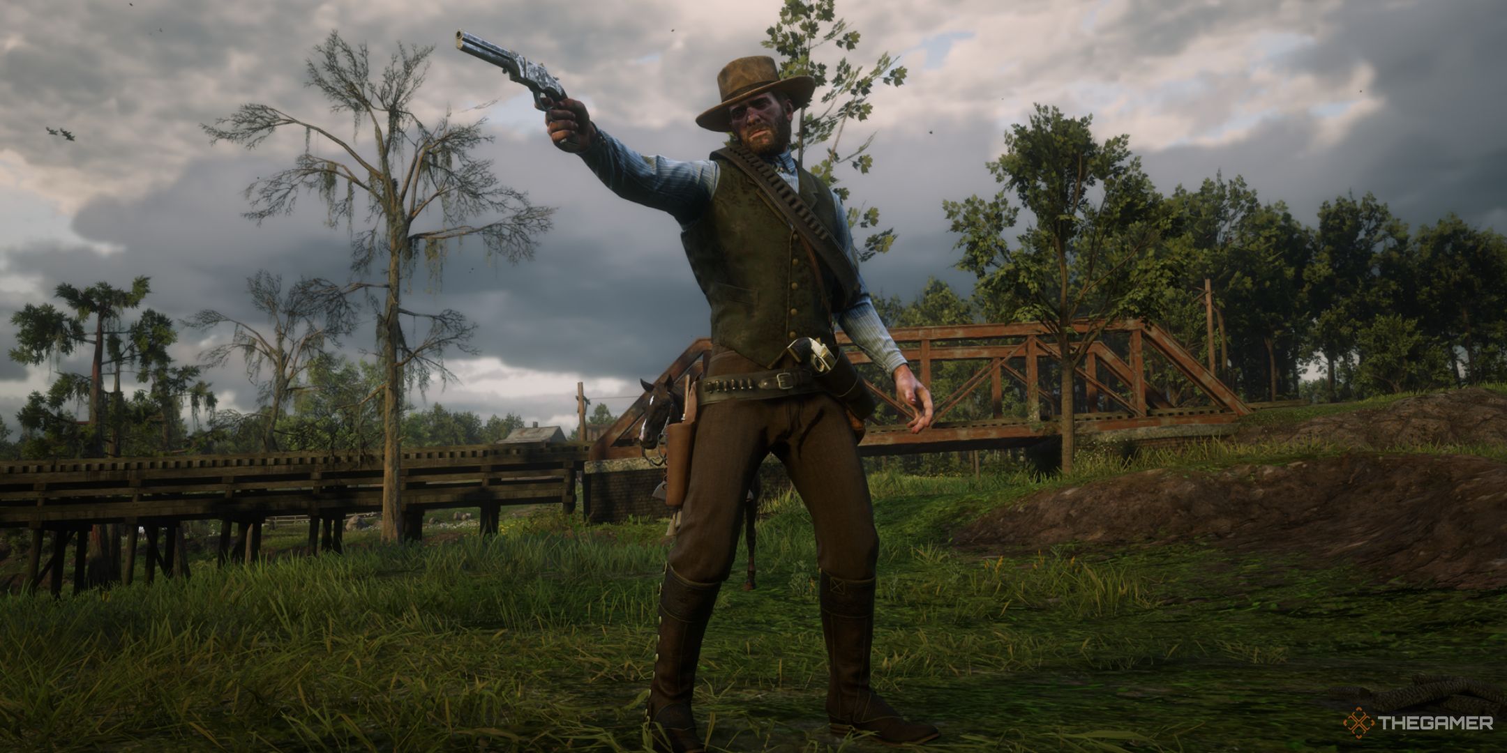 Red Dead Redemption 2 screenshot of Arthur Morgan wearing The Heartlands outfit while pointing a gun.