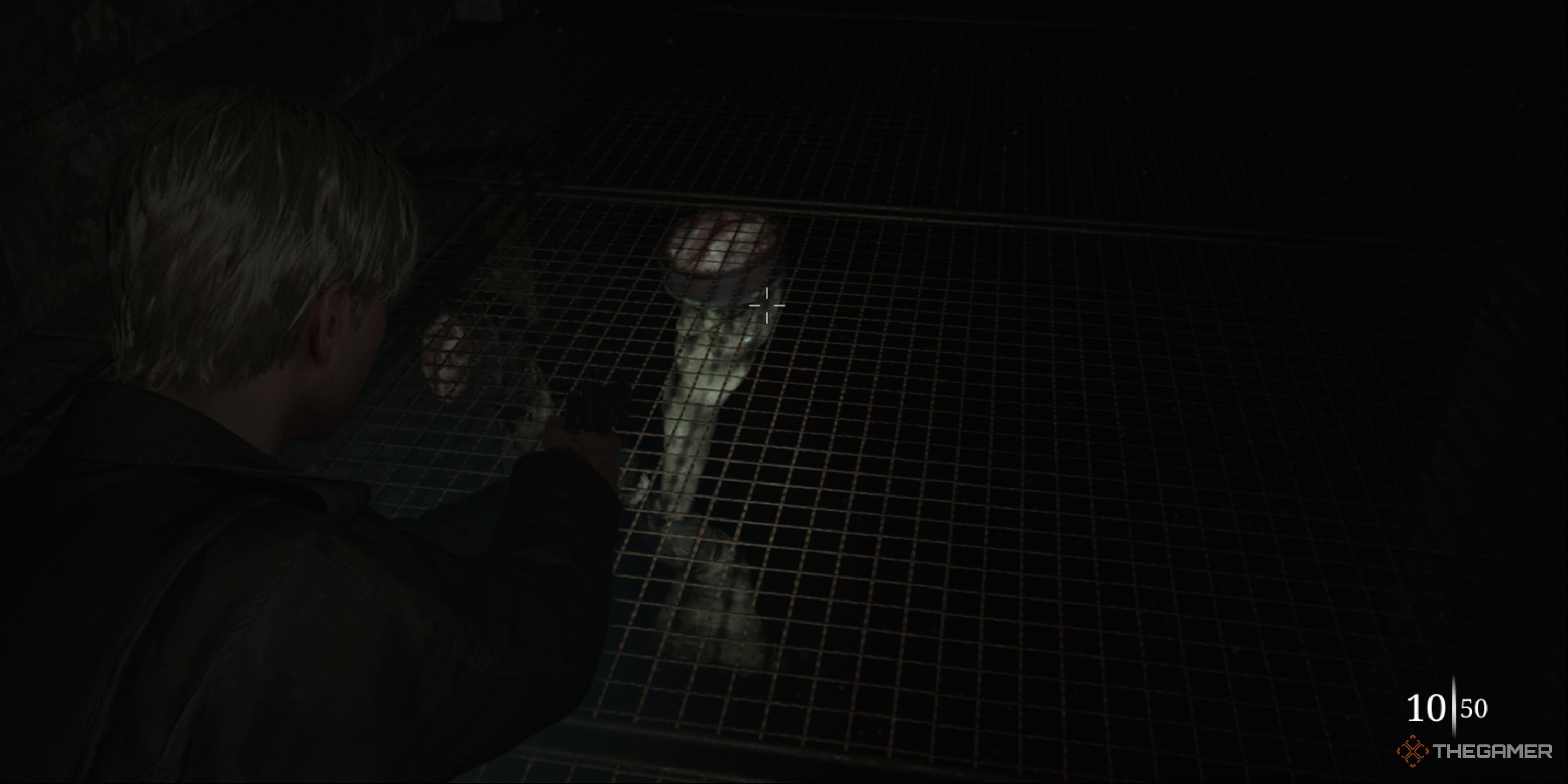 Silent Hill 2 - James aiming his gun at a Mandarin monster that&rsquo;s suctioning to the caged floor below him.