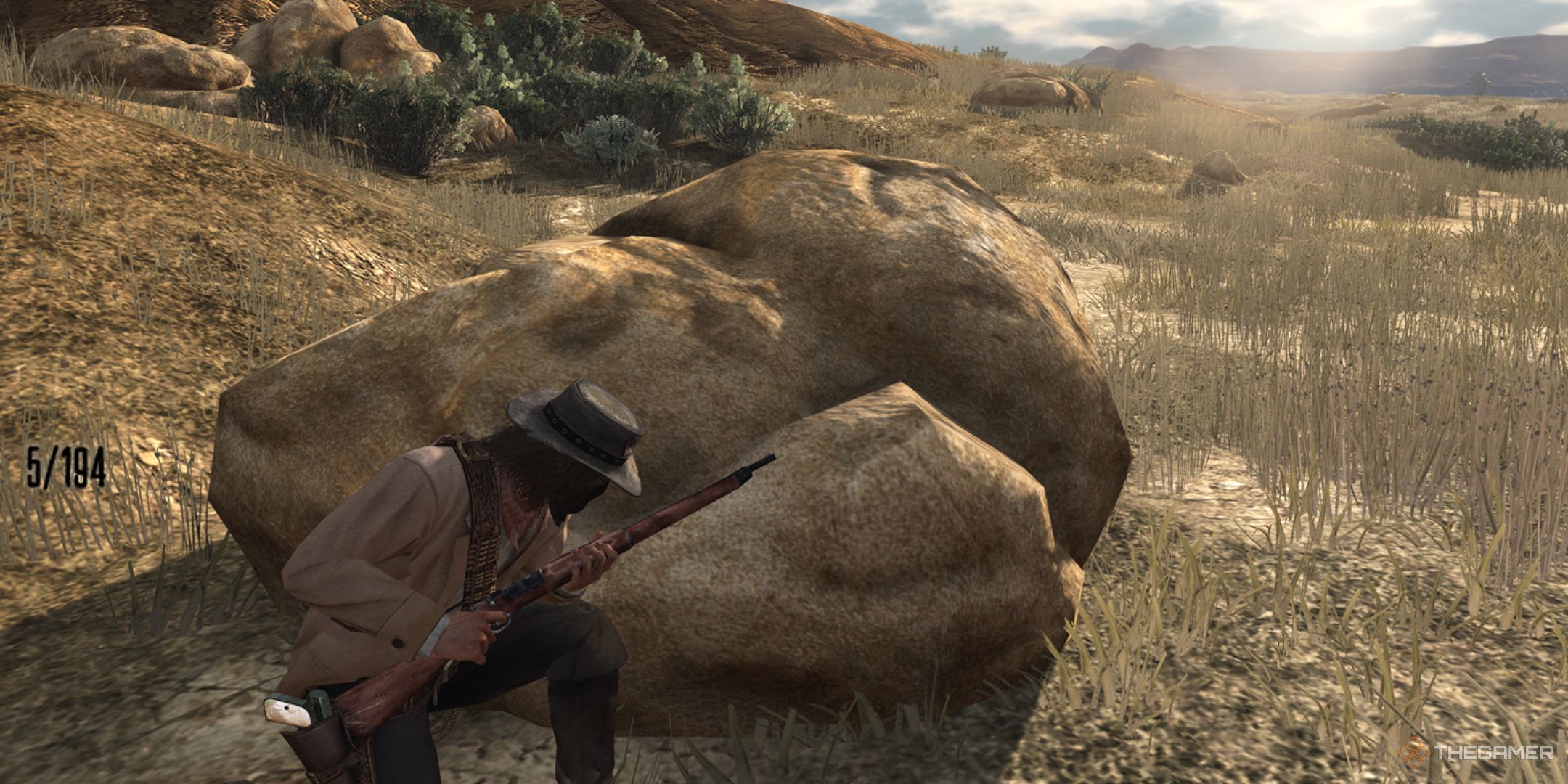 Red Dead Redemption screenshot of protagonist in cover while holding a bolt action rifle.