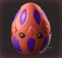 Close up view of a bright red egg with dark purple markings and black dots in Luma Island.