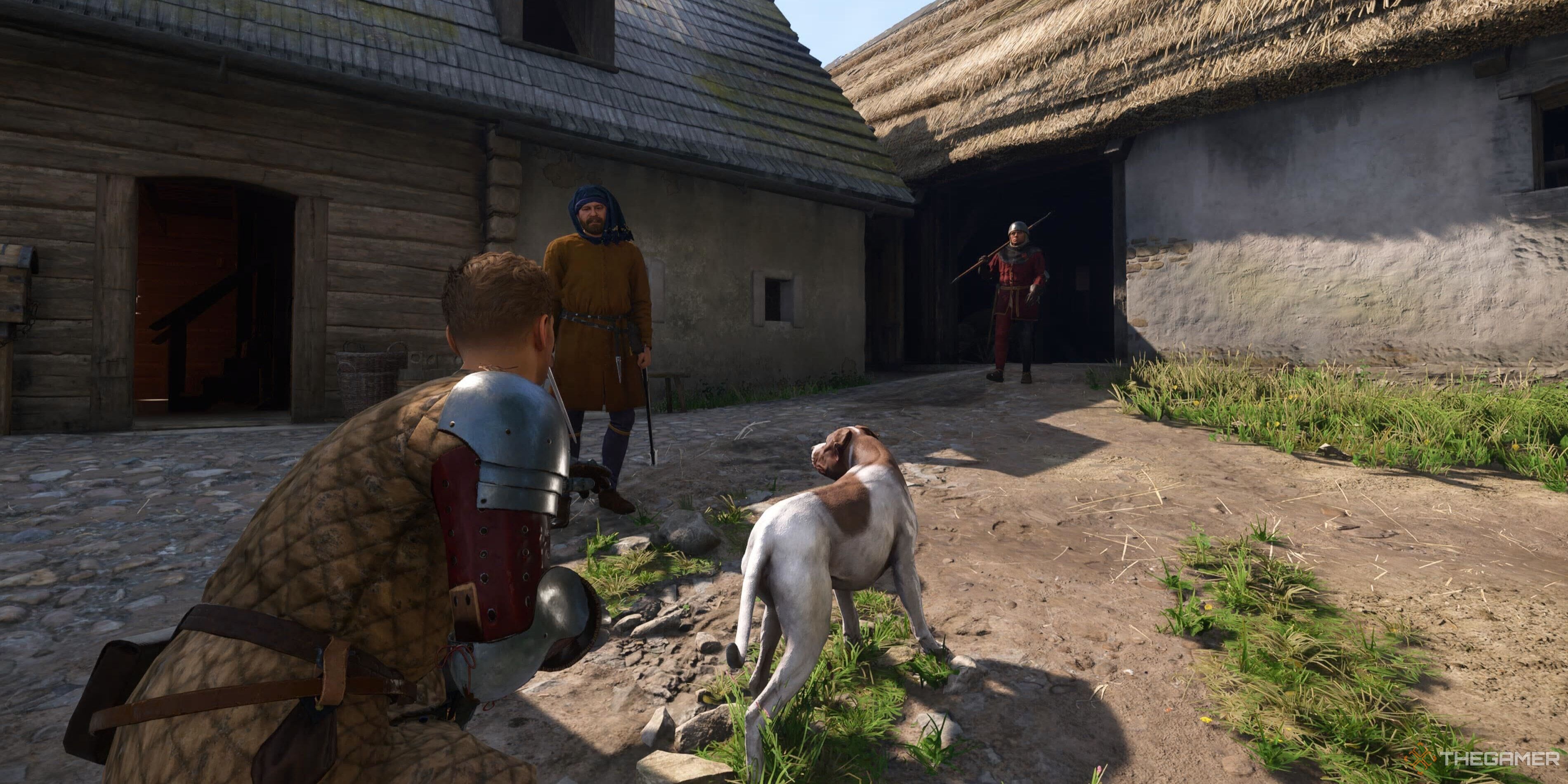 Henry crouching next to a dog in Kingdom Come: Deliverance 2.