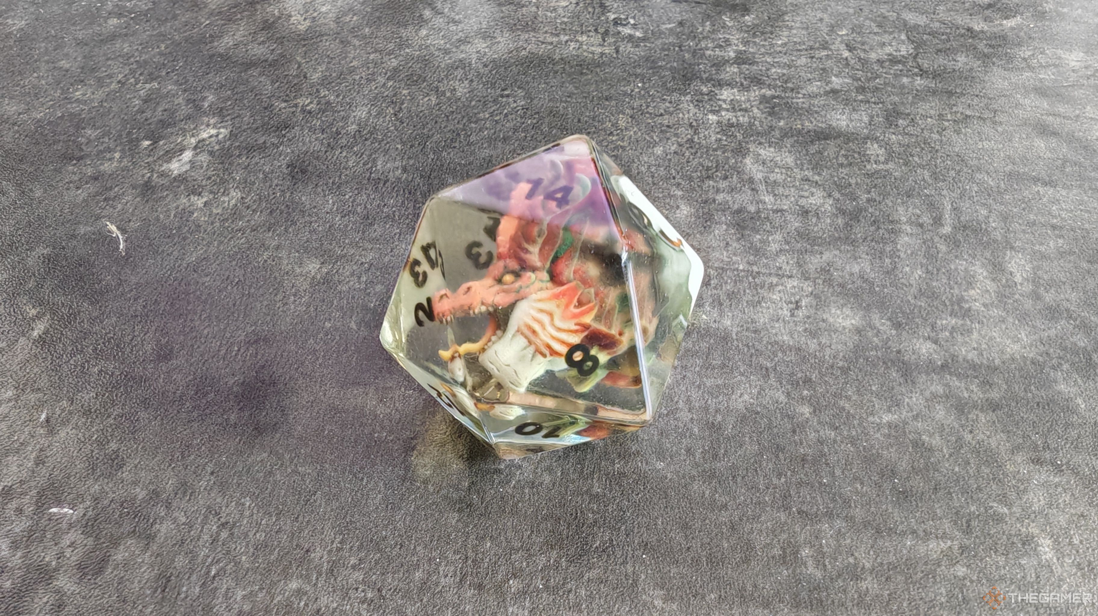 A clear d20 dice with dragon head inside