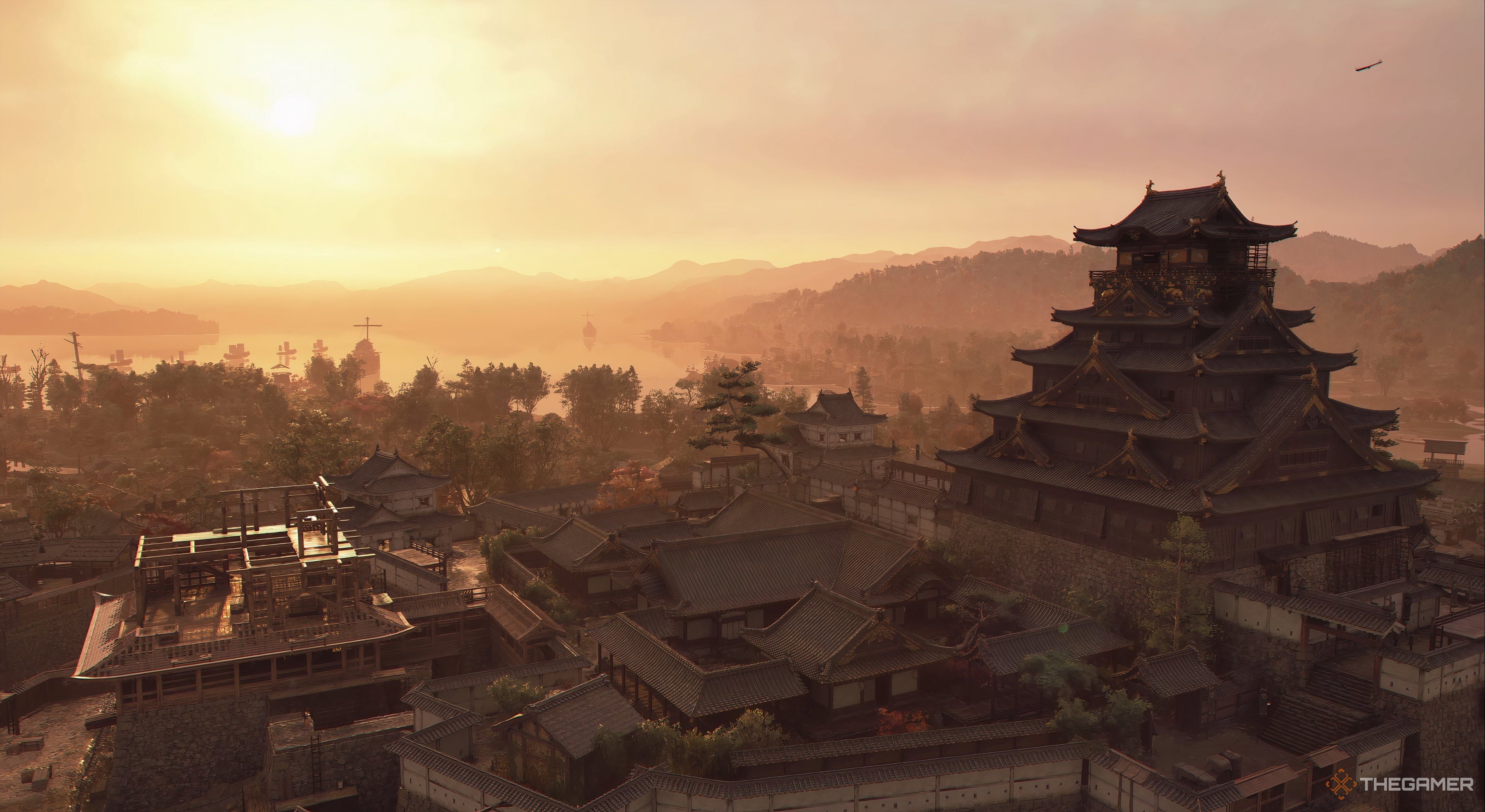 Assassins Creed Shadows an above ground view of the castle with tower off to the right. The sun is located beside the tower. There are smaller building around the tower.