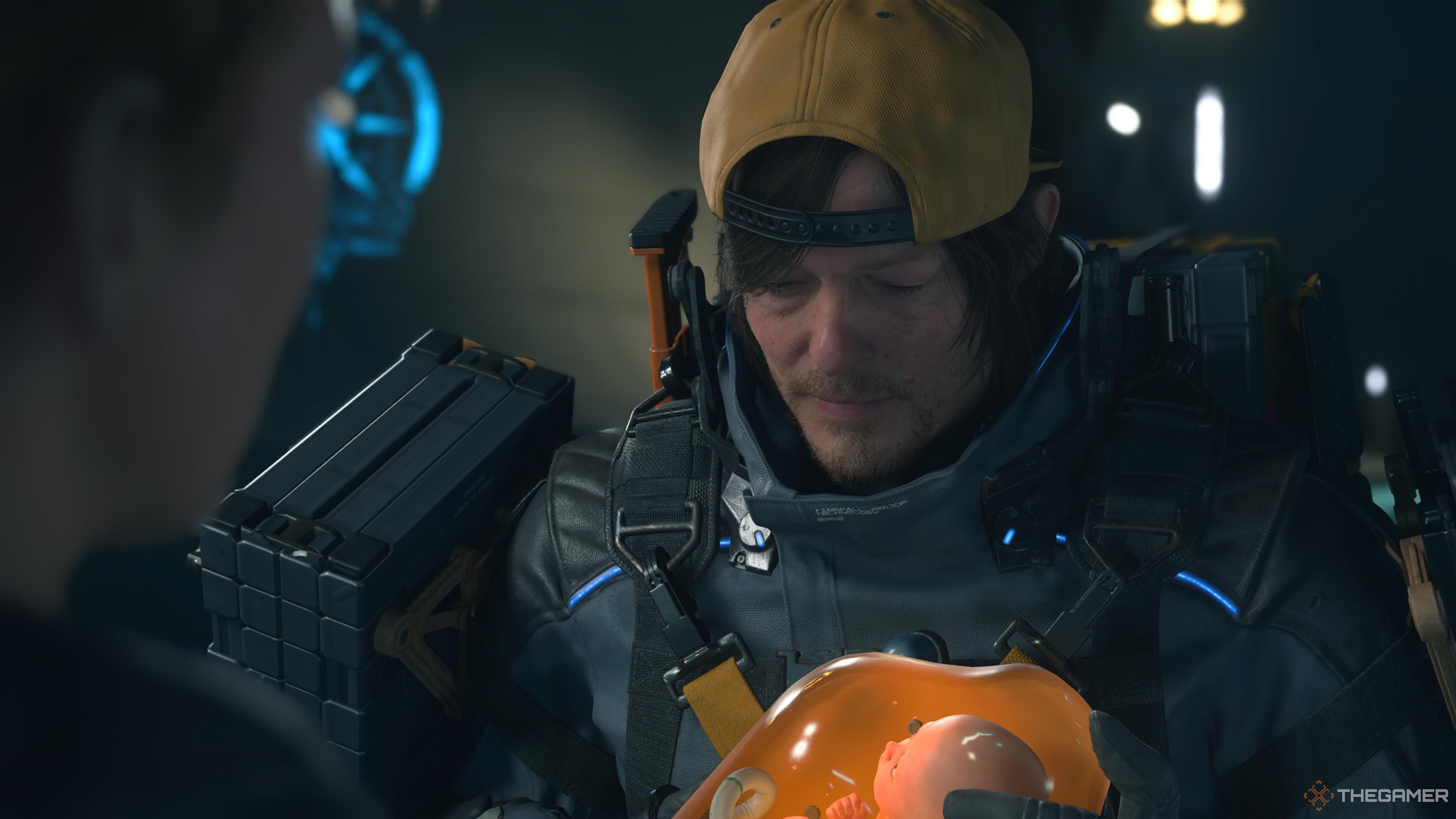 Sam with Lou in a BB pod in death stranding 2 on the beach.